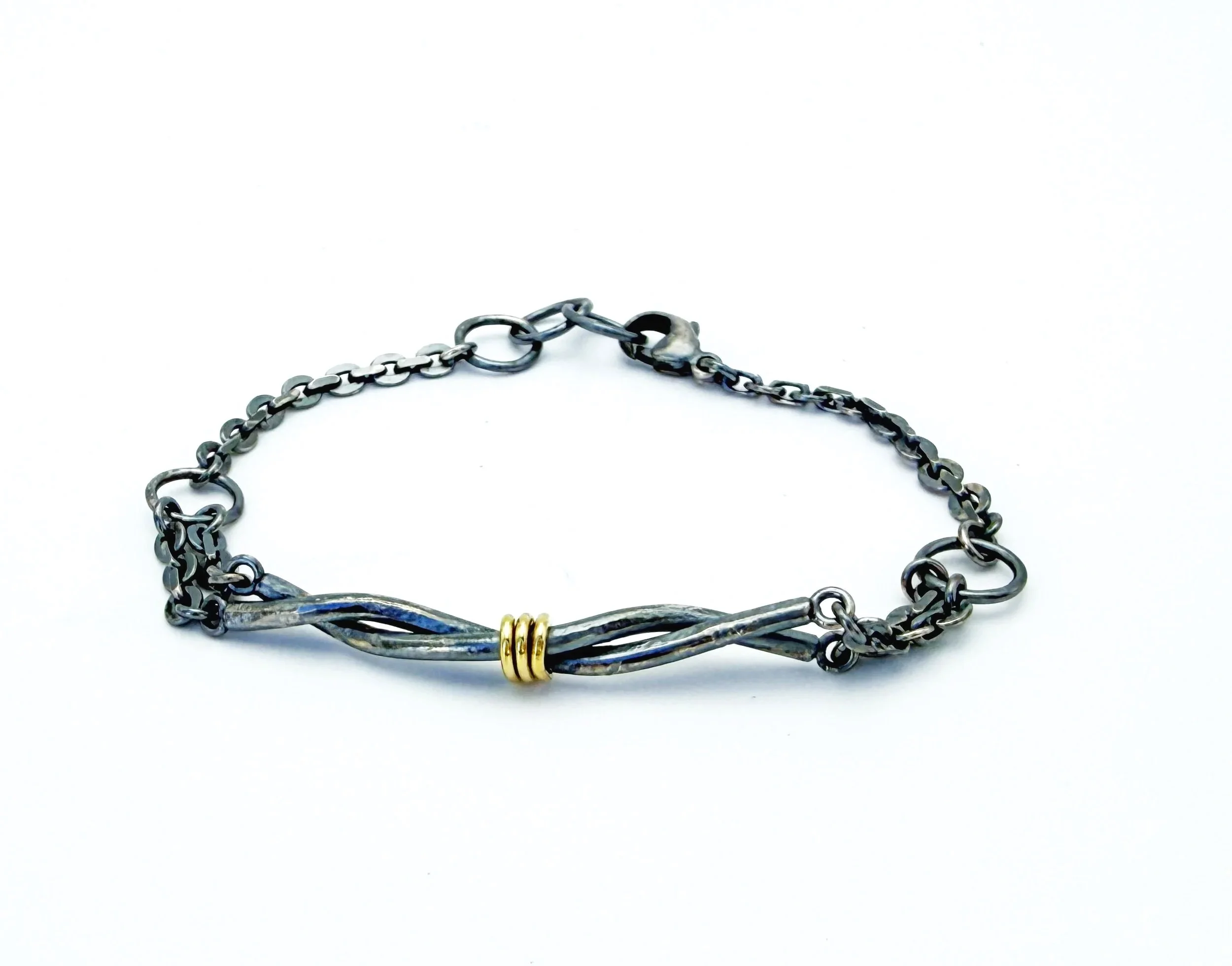 Oxidized silver twist bracelet with a 14k gold wire wrap, on white
