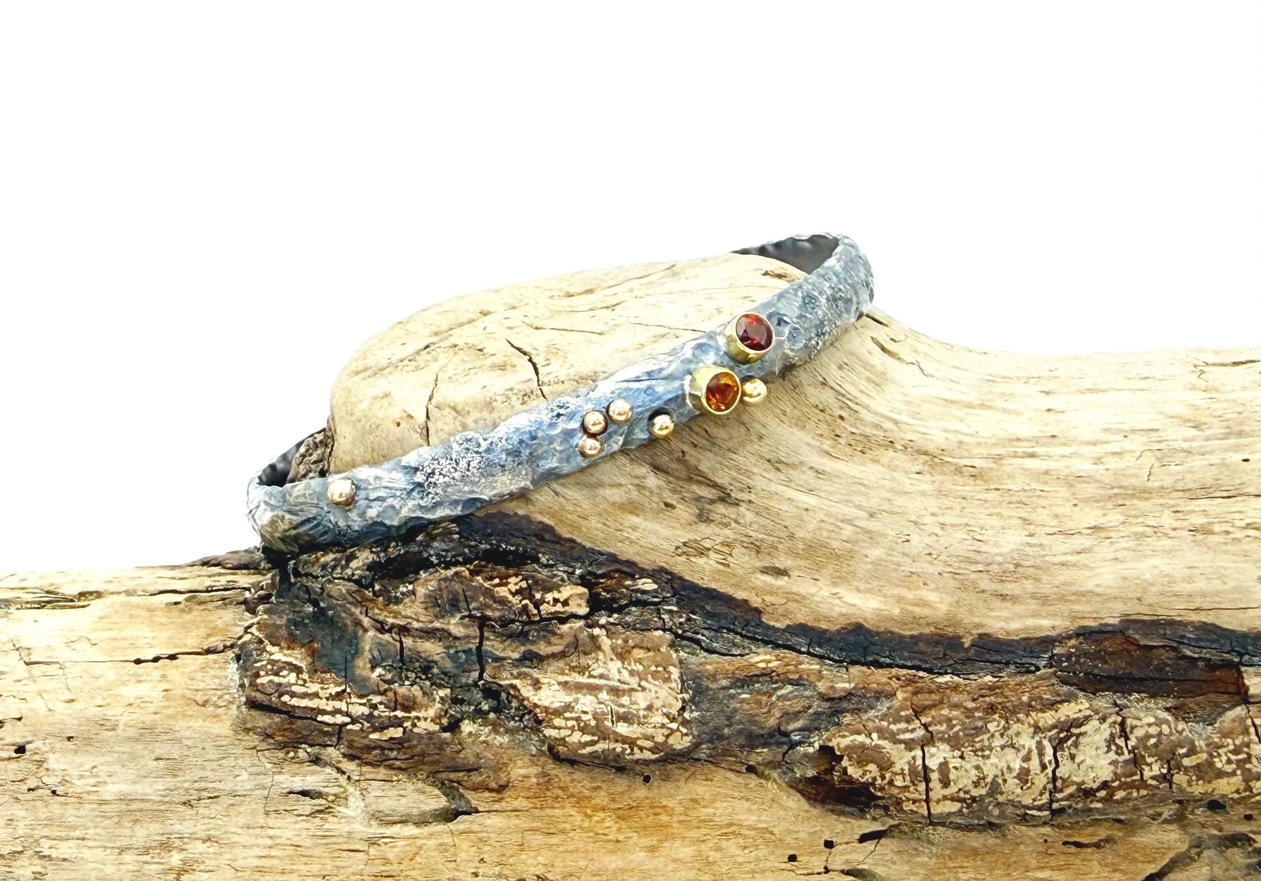 Textured oxidized silver cuff with garnet, citrine and 14k gold dots, on driftwood