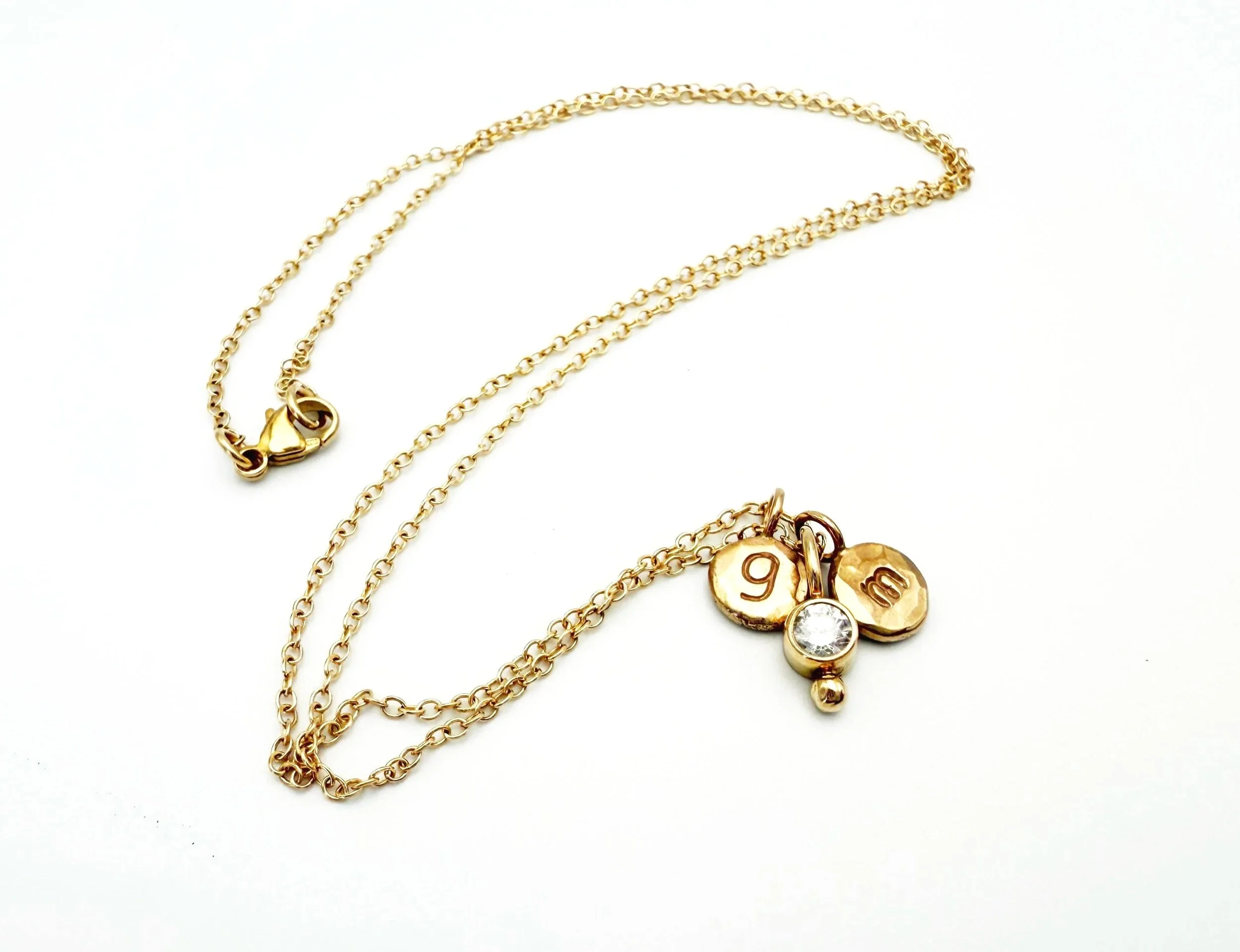 customized gold disc necklace with stamped initials and diamond solitaire