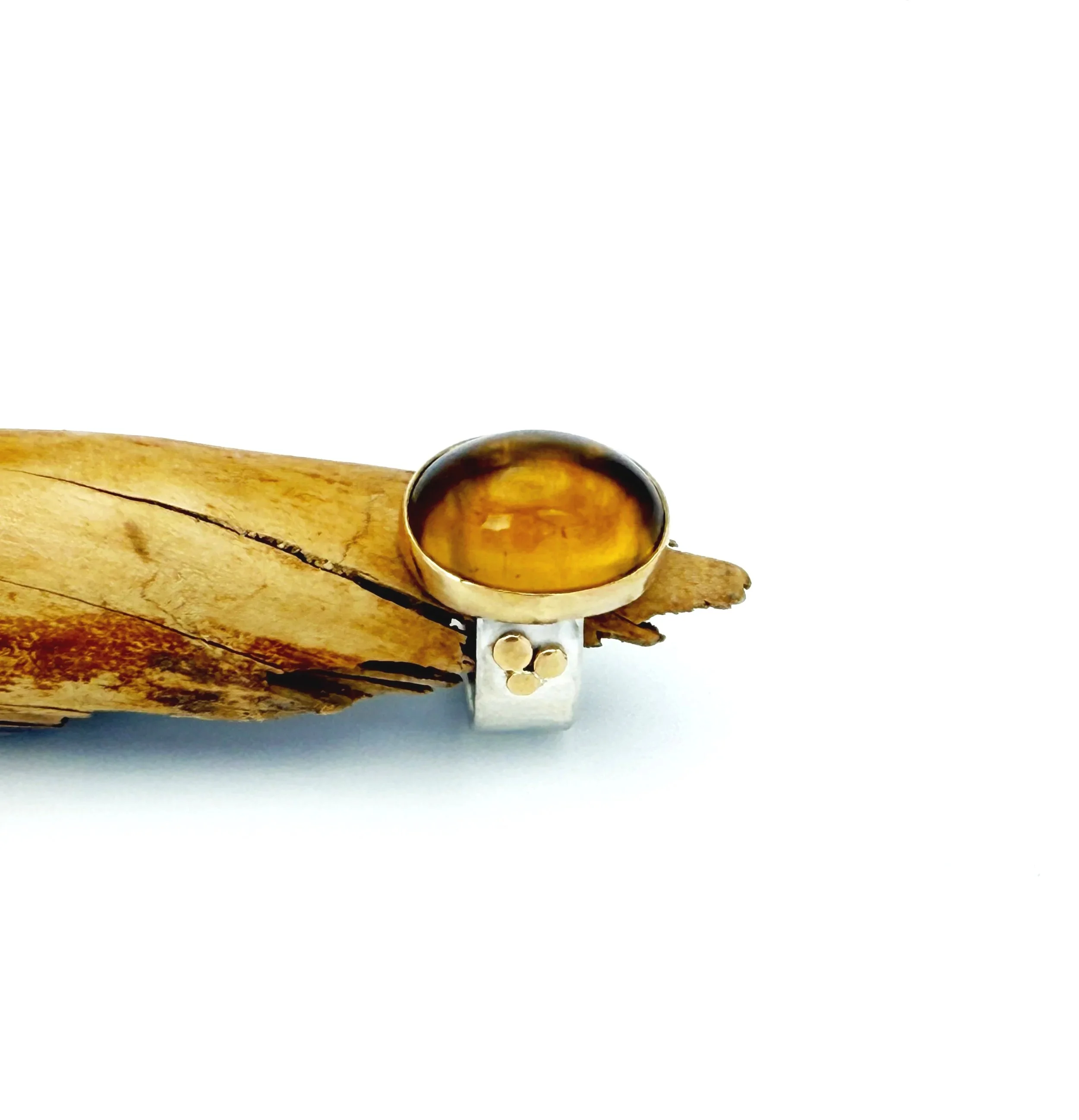 Side view of the citrine ring on driftwood, showing the high dome