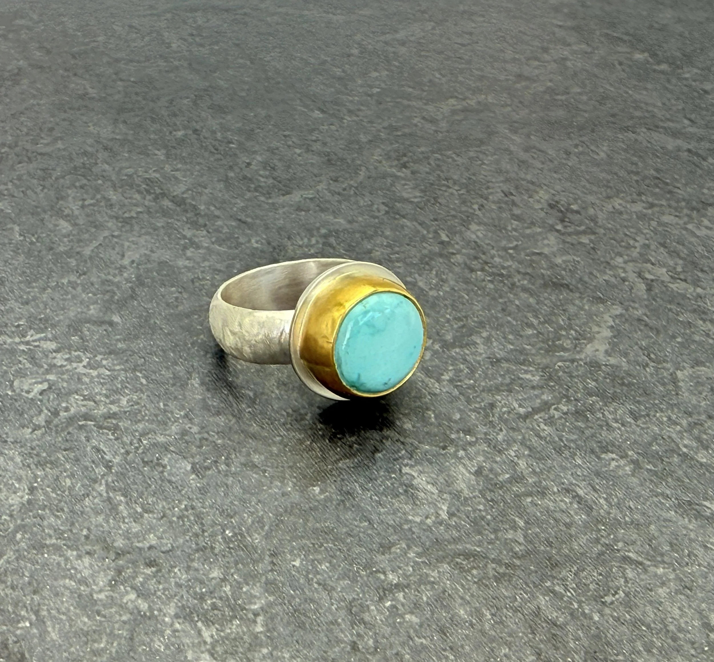 Turquoise and 22k gold bezel ring on dark slate