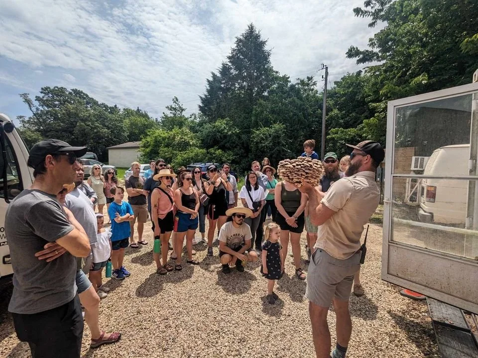Farmer Shawn shows a tour group a shiitake mushroom block