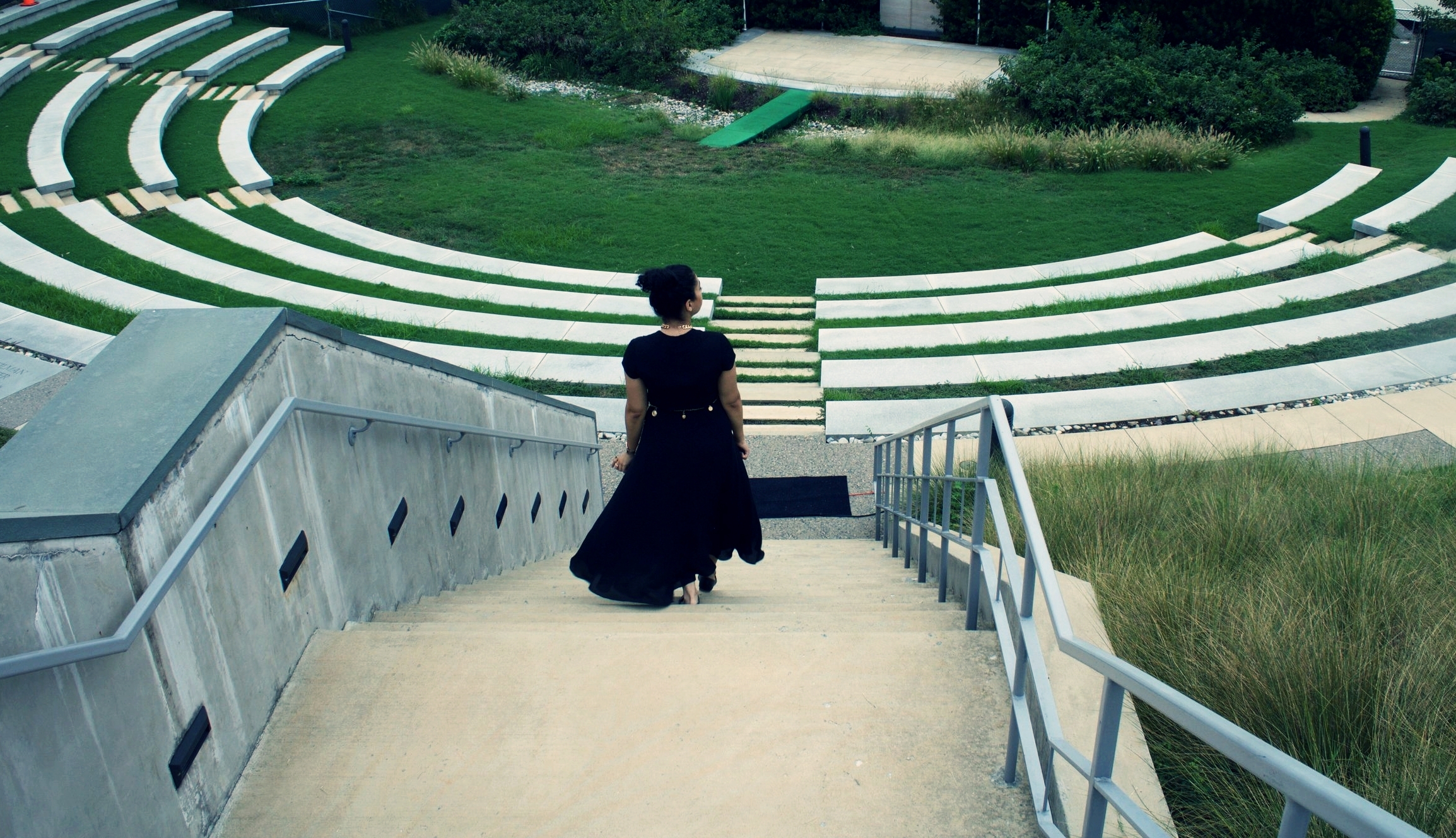 As one makes her way down to the landscape, it is impossible but to notice the elegance, harmony, and simple yet strong amphitheater which is an ode and extended complement of the marble Shrine sitting directly atop. The ornamental grasses surroundi…