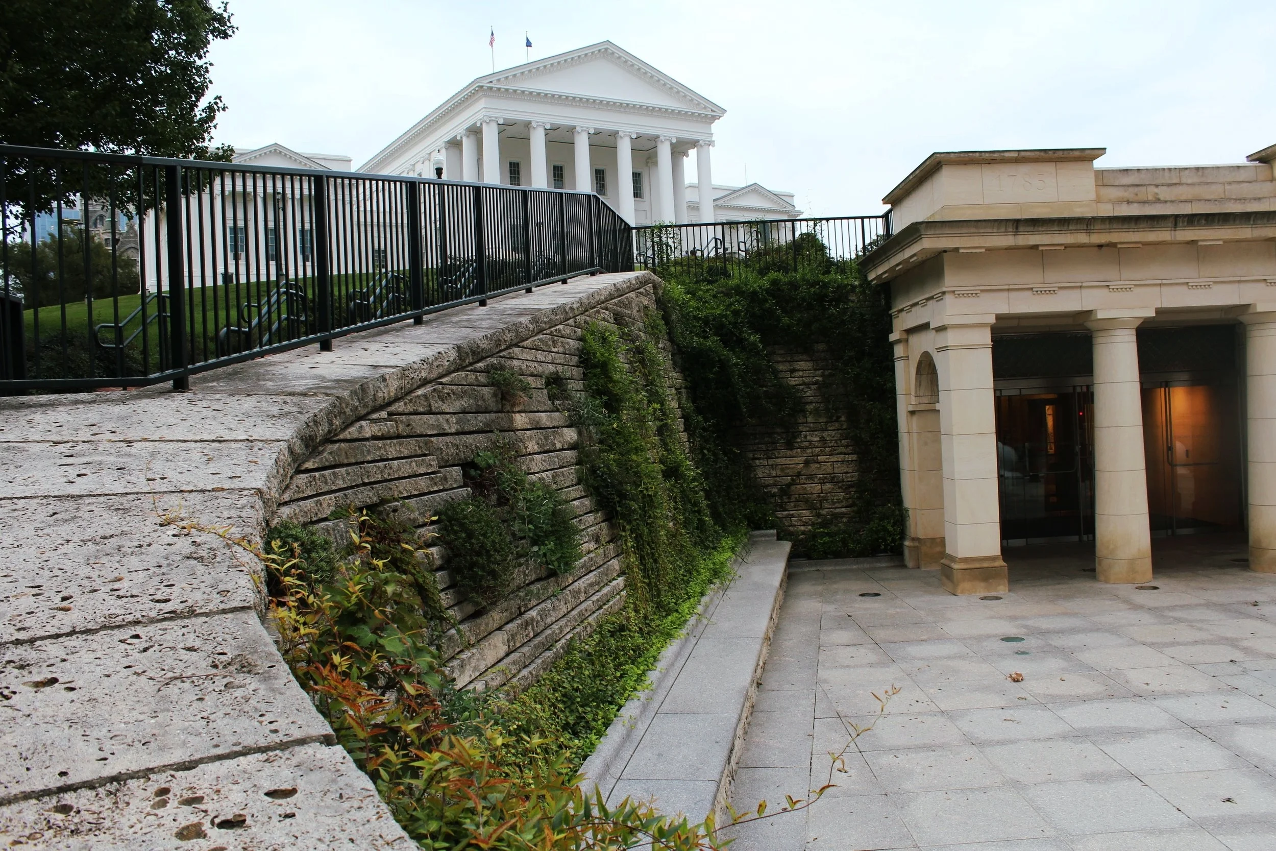 A true meeting point of architecture and landscape, the twist of planting at the entrance plaza creates a visual interest, while making the large wall more human-scale and breaking up the all around grey feel of the plaza.
