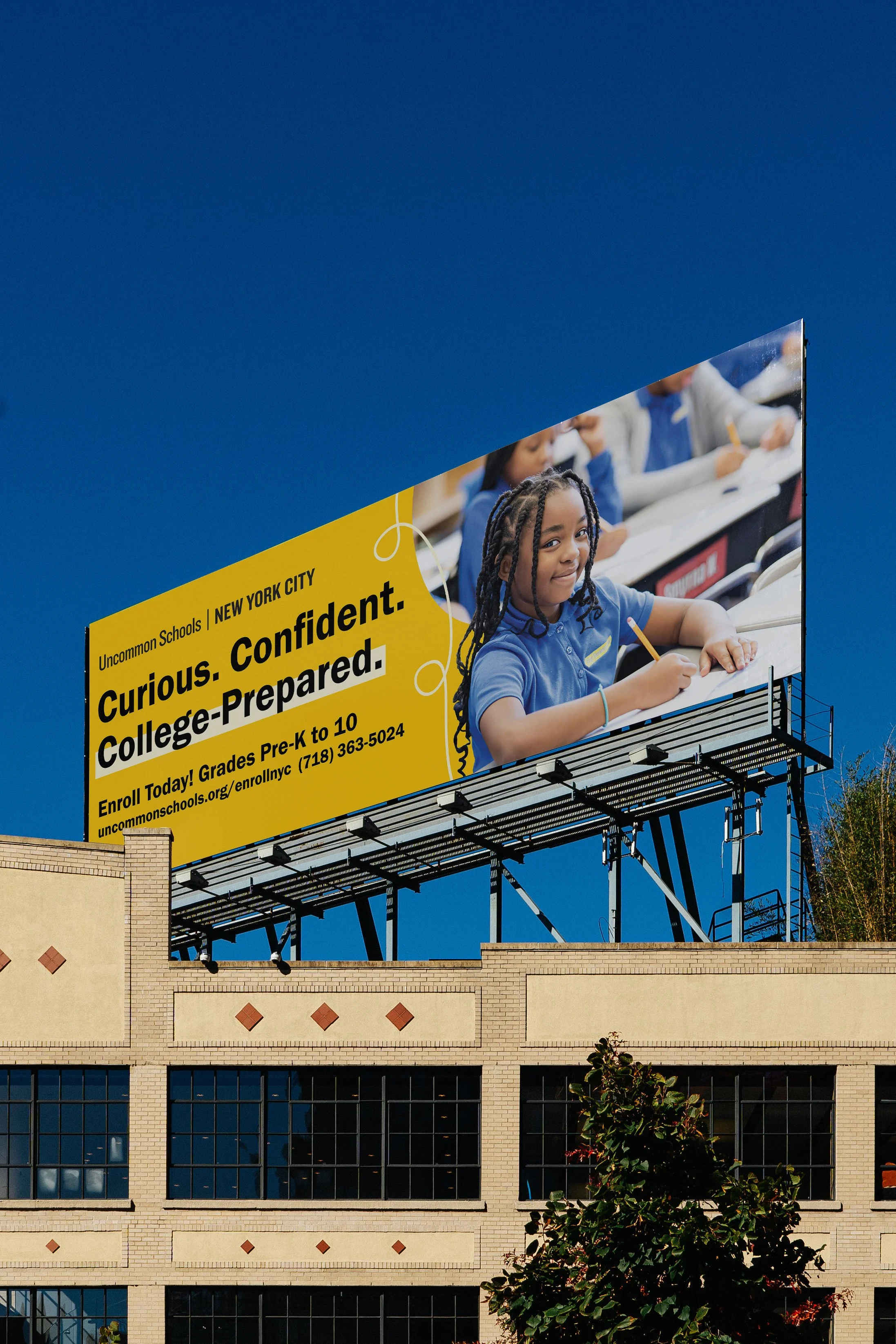Billboard advertisement for Uncommon Schools in New York City, promoting college preparedness for children from pre-kindergarten to 10th grade, featuring a young girl in a classroom.