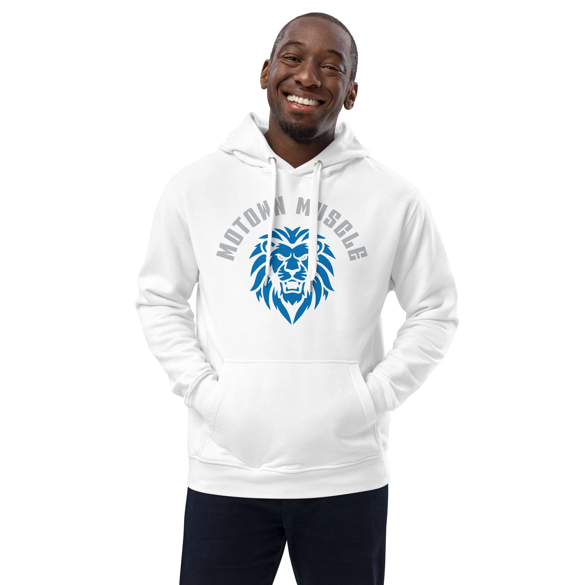 Person wearing a white hoodie with a blue lion graphic and the words 'Motown Muscle' on the front, black pants, standing and smiling against a black background.