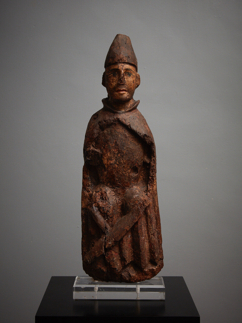 Romanesque Statue Late 13th - early 14th century, Iberian (probably Pyrennes) 590 x 200 x 95mm Provenance: Private collection, Madrid, Spain. A wooden sculpture of a seated male figure, wearing a conical hat, long robe, and cape. This is almost c