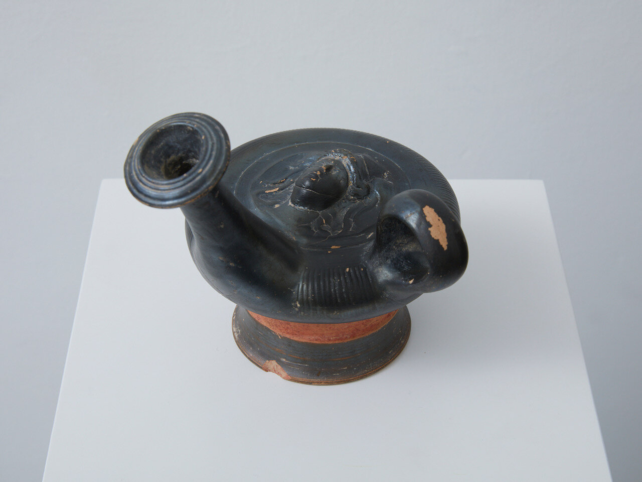 Apulian Black-Glazed Guttus Hellenistic period, 2nd half of the 4th century BC, Western Greek, Apulia 130 x 140 x 155mm Provenance: Private collection, West Germany. Apulian black-glazed guttus made from toned clay with ribbed body and ring handl