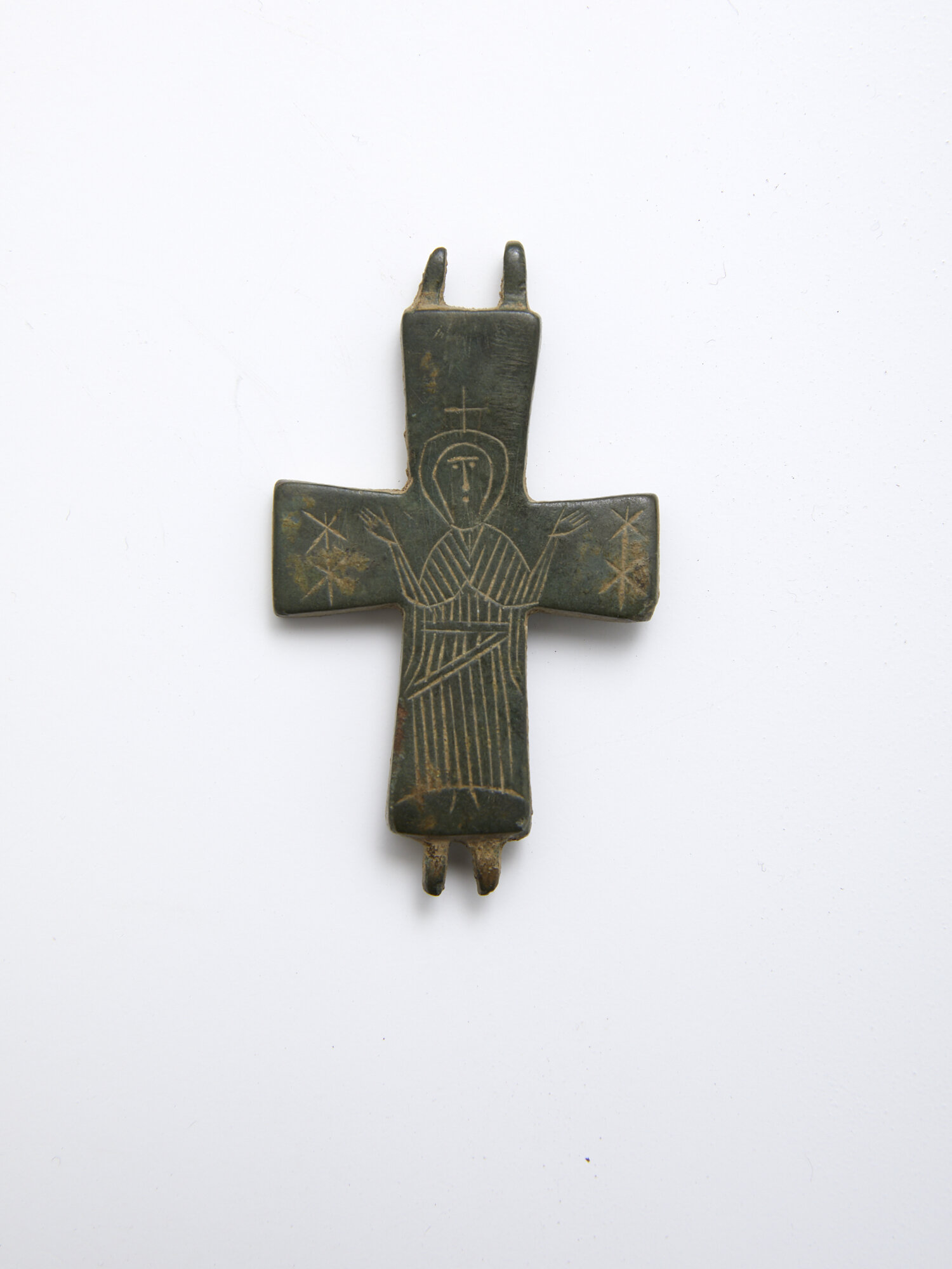 Bronze Enkolpion Middle Byzantine Period, 10th - 12th century AD, Byzantium (Eastern Roman Empire) 60 x 40 x 5mm Provenance: Private collection, Munich, Germany. Half of a bronze enkolpion (medallion) with engraved figure standing in the attitude