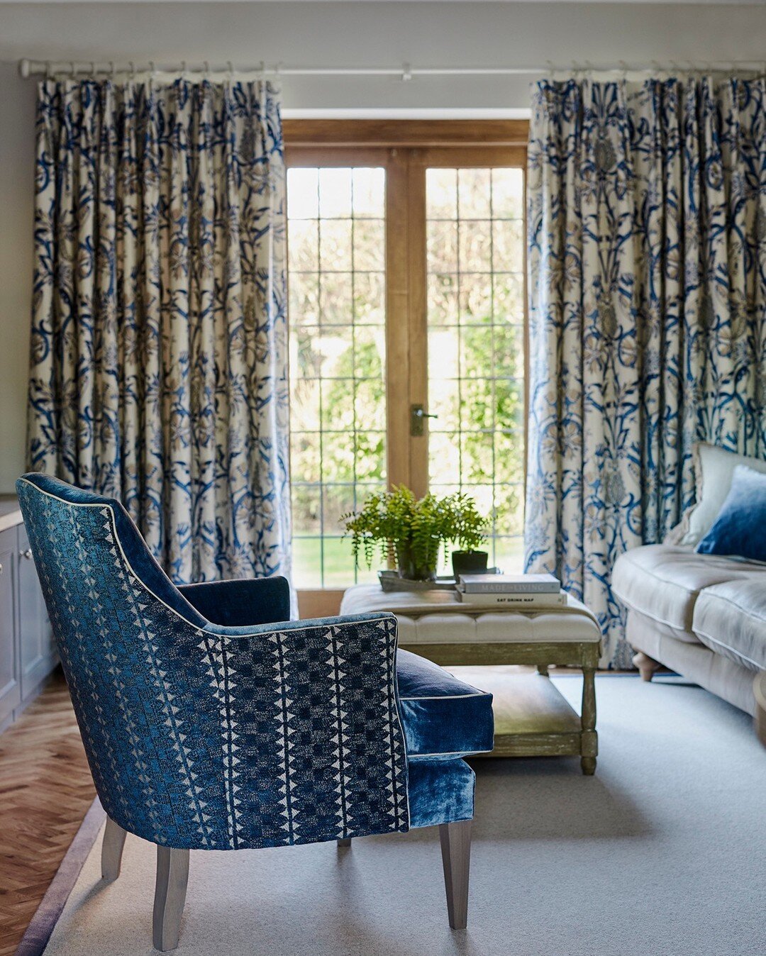 This beautiful corner of a study provides the perfect place to relax and look out on to the stunning garden. We love the use of different patterns in this room as well - both on the curtain fabric and on the back of this striking armchair. ​​​​​​​​
​