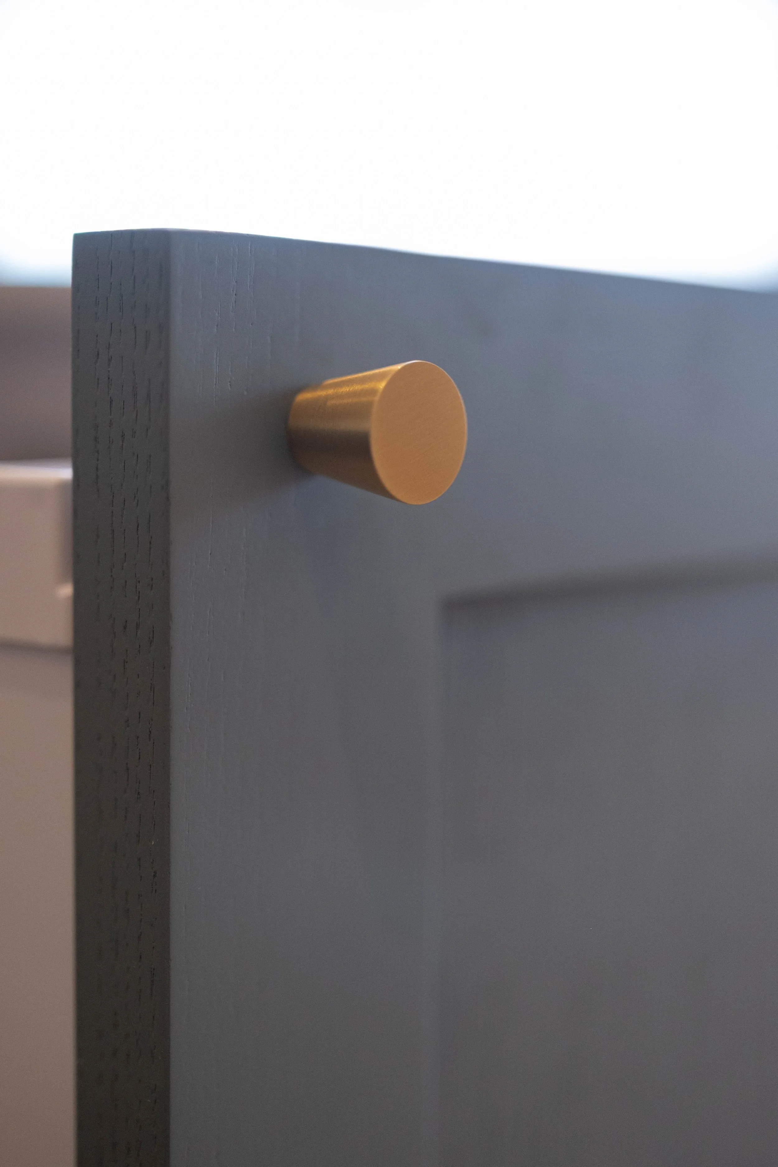 Close-up of a drawer with a round, gold-colored handle.
