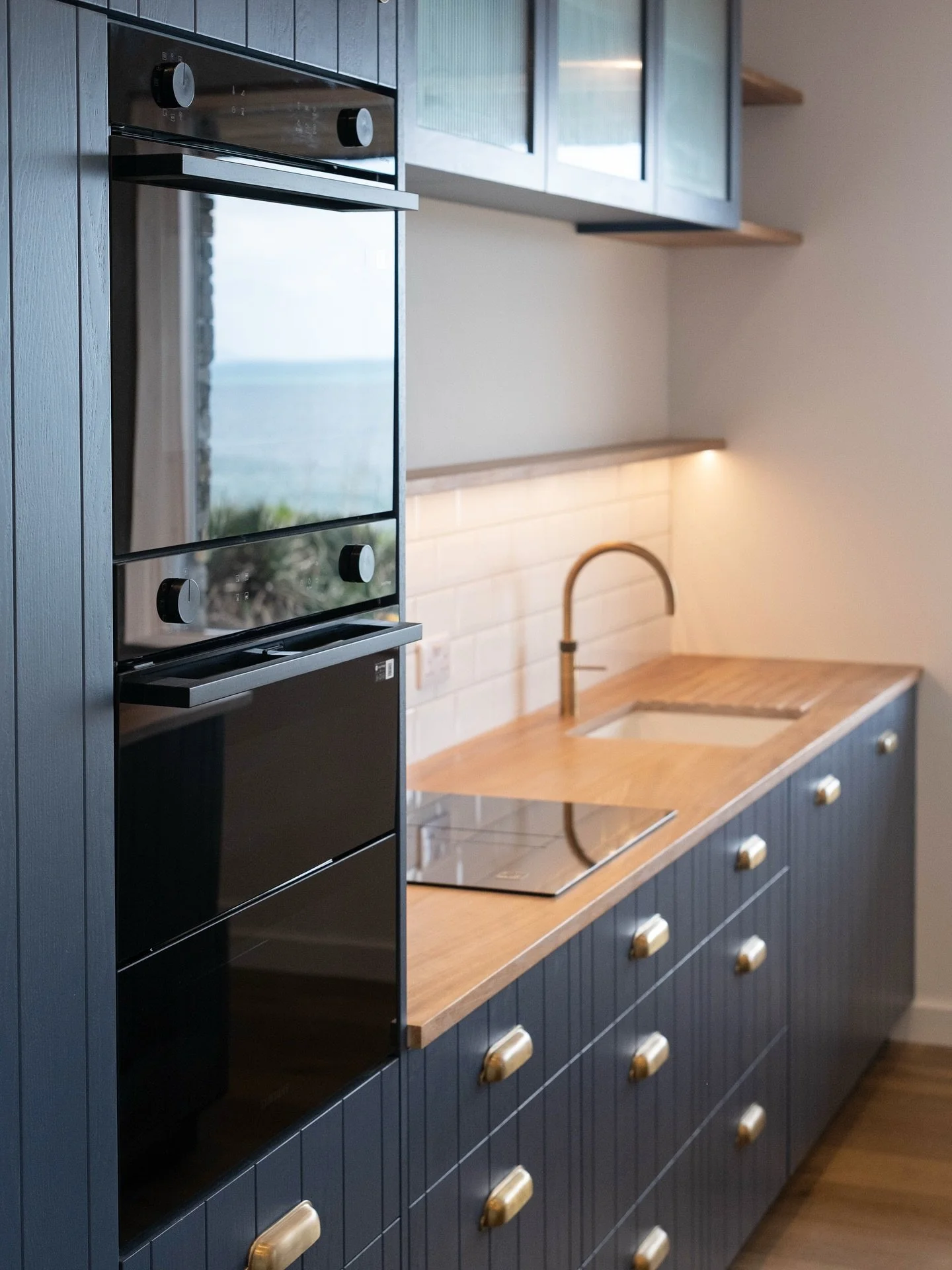 Some more angles of this painted ash kitchen with tongue &amp; groove detailing - the variation in the natural grain mixed with the straight lines of the T&amp;G gives a beautiful finish. 

Also featured in the project:
Quooker Fusion tap in patinate