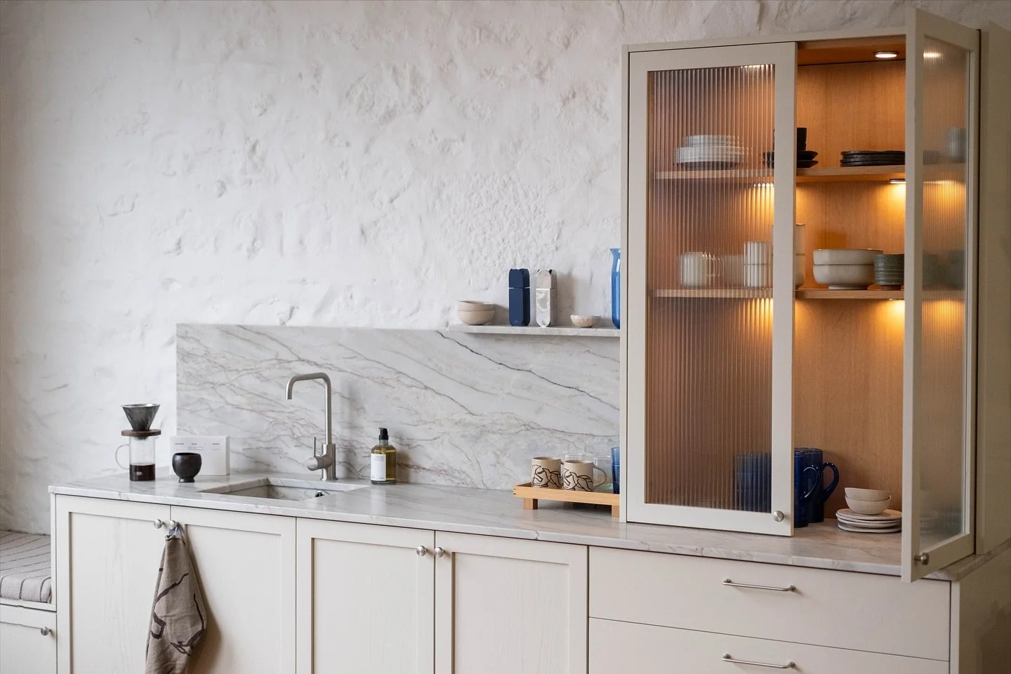 Painted to Paint and Paper Library Stone, and mixed with a White American Oak glass unit there is a lovely relaxing tone to this kitchen area. The solid ash shaker doors are made with 50mm thick stiles, and slab drawers, to give a paired back feel. 
