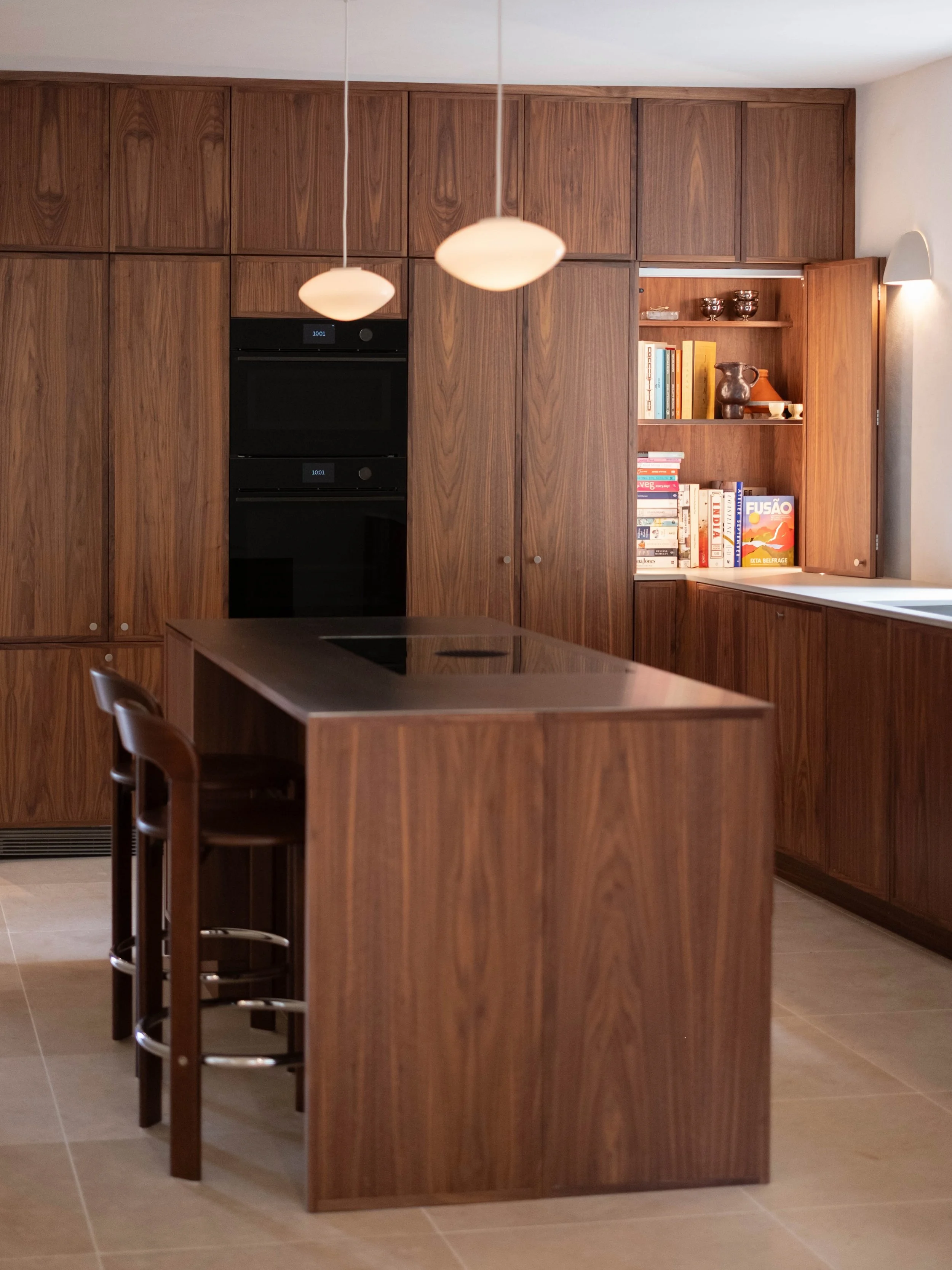 Surrounded by trees, and with views of the garden from every angle, we designed this kitchen to blend in with its natural surroundings. 

Walnut is a great choice for this room, as it ages and becomes a more golden honey colour and works so well with