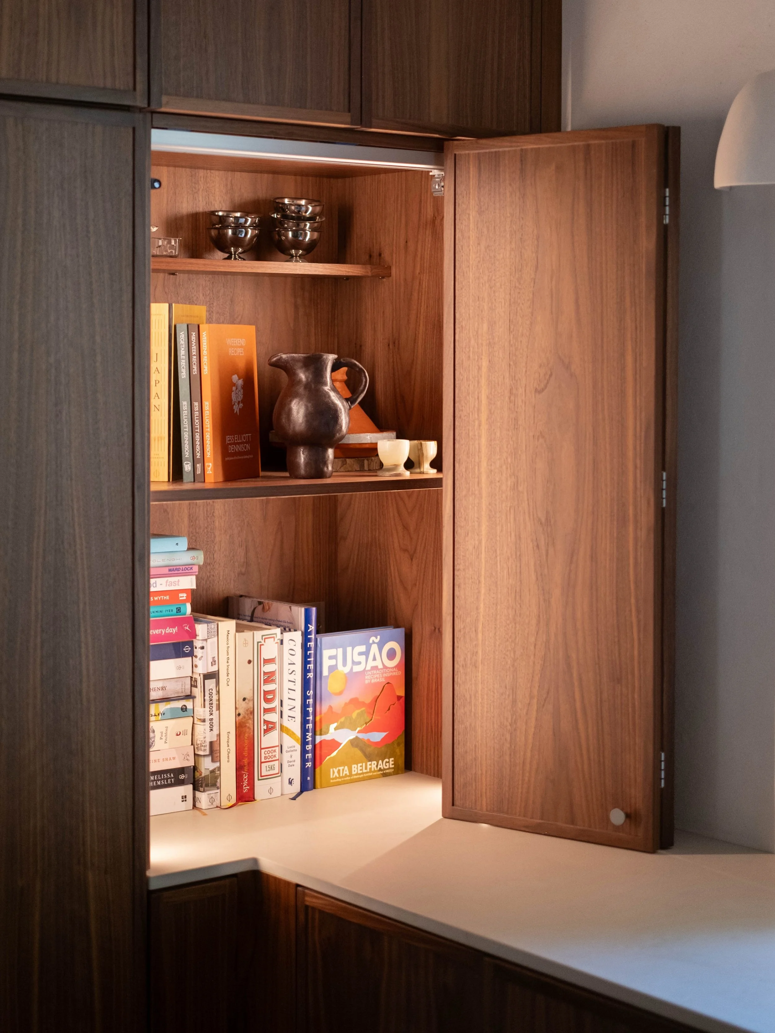 Walnut is a beautiful material to work with in a kitchen: it deepens into a rich, golden honey tone as it ages, and its natural grain brings a real sense of character to every surface it touches.

A sliding dresser door opens on a concealed track to 