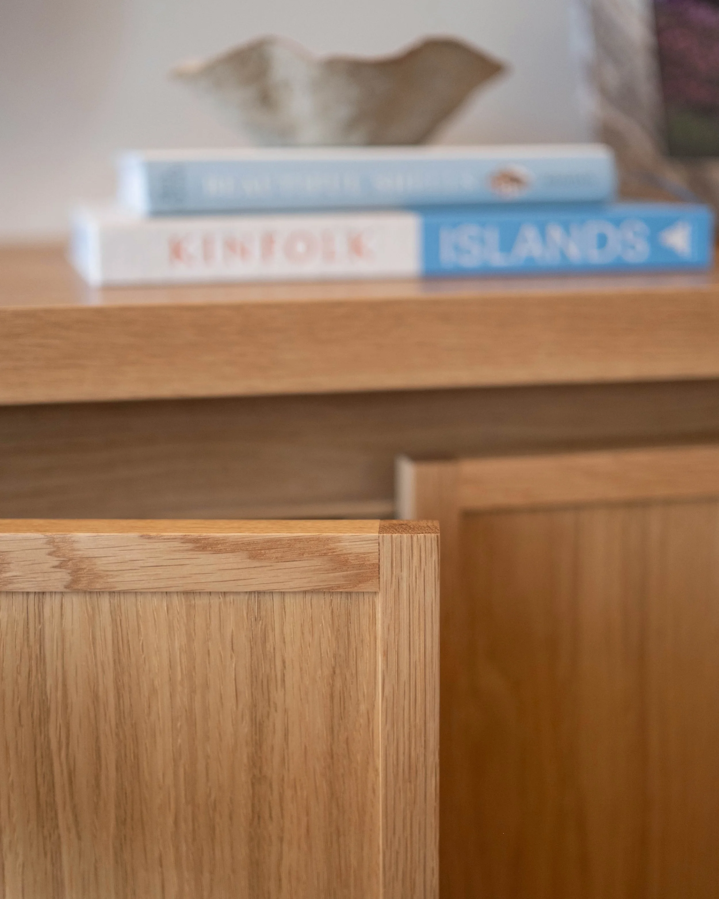 Two different handle-less door options in this series. 

The skinny shaker unit features an oak rail that sits behind the doors, allowing you to open the door from behind without the need for any handle mounted onto, or routed into the door itself. 
