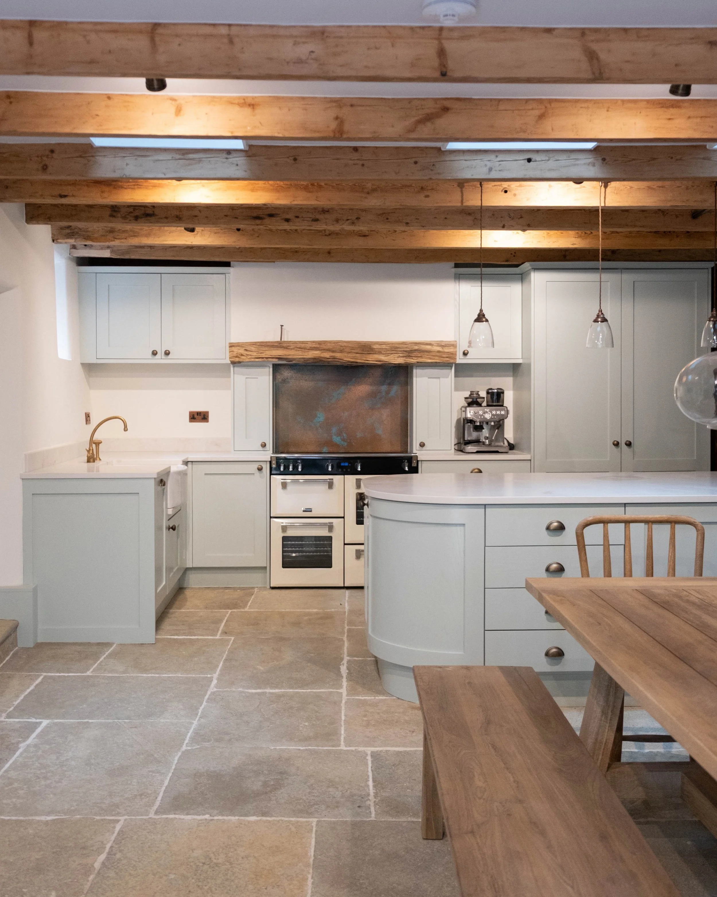 The kitchen we did for this project sits inside a water mill dating back to the 15th century, with much of the original machinery still built into the room. Ash shaker doors were hand made and sprayed in Dulux Heritage Green Slate, traditional cornic