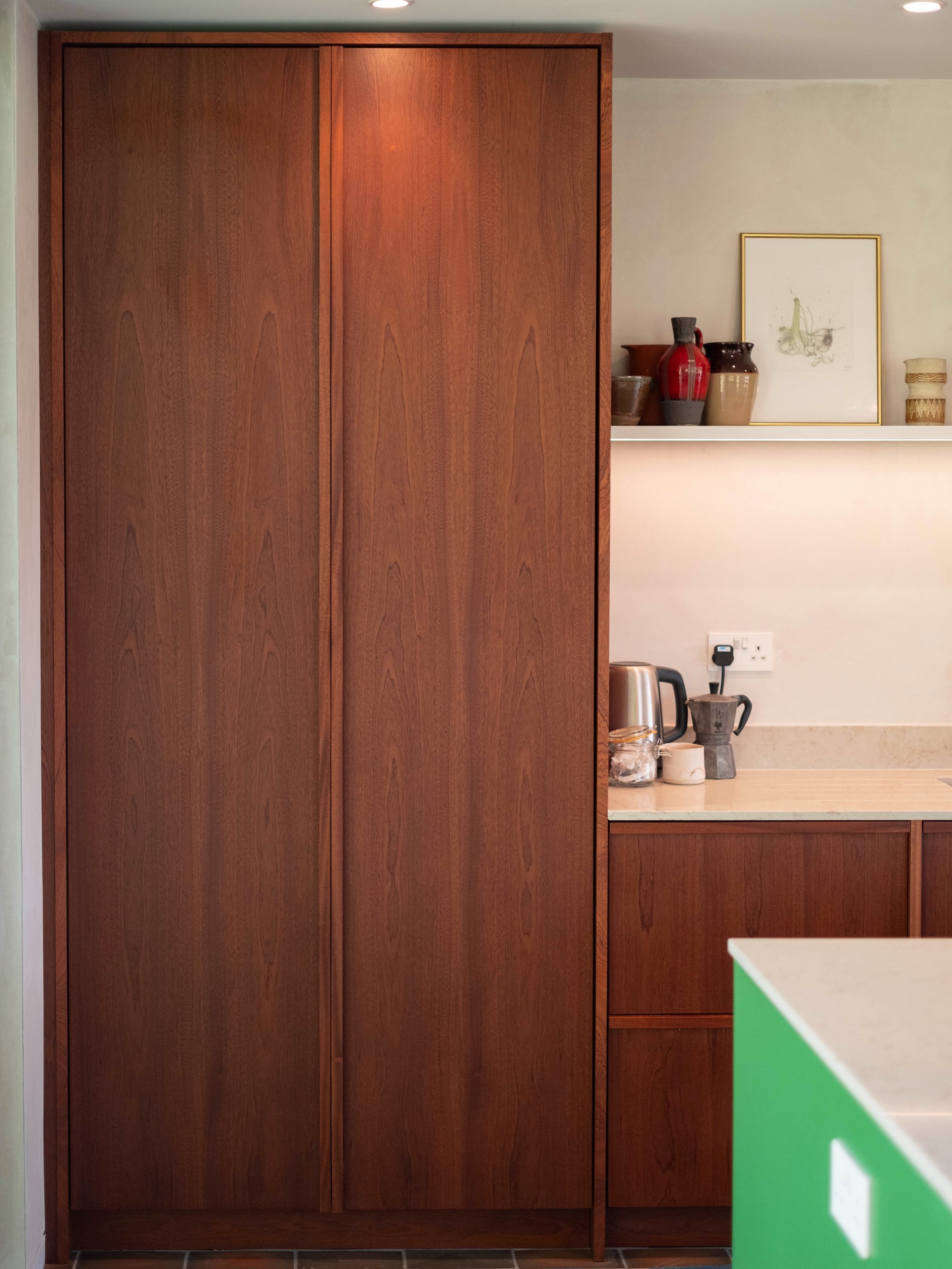 Field House, Pancrasweek

A bright, open plan room in North Cornwall. Bookmatched Sapele runs the full height of the main wall, with dovetailed Sapele drawers hidden inside the larder. The island is painted in YesColours Iconic Green with open booksh