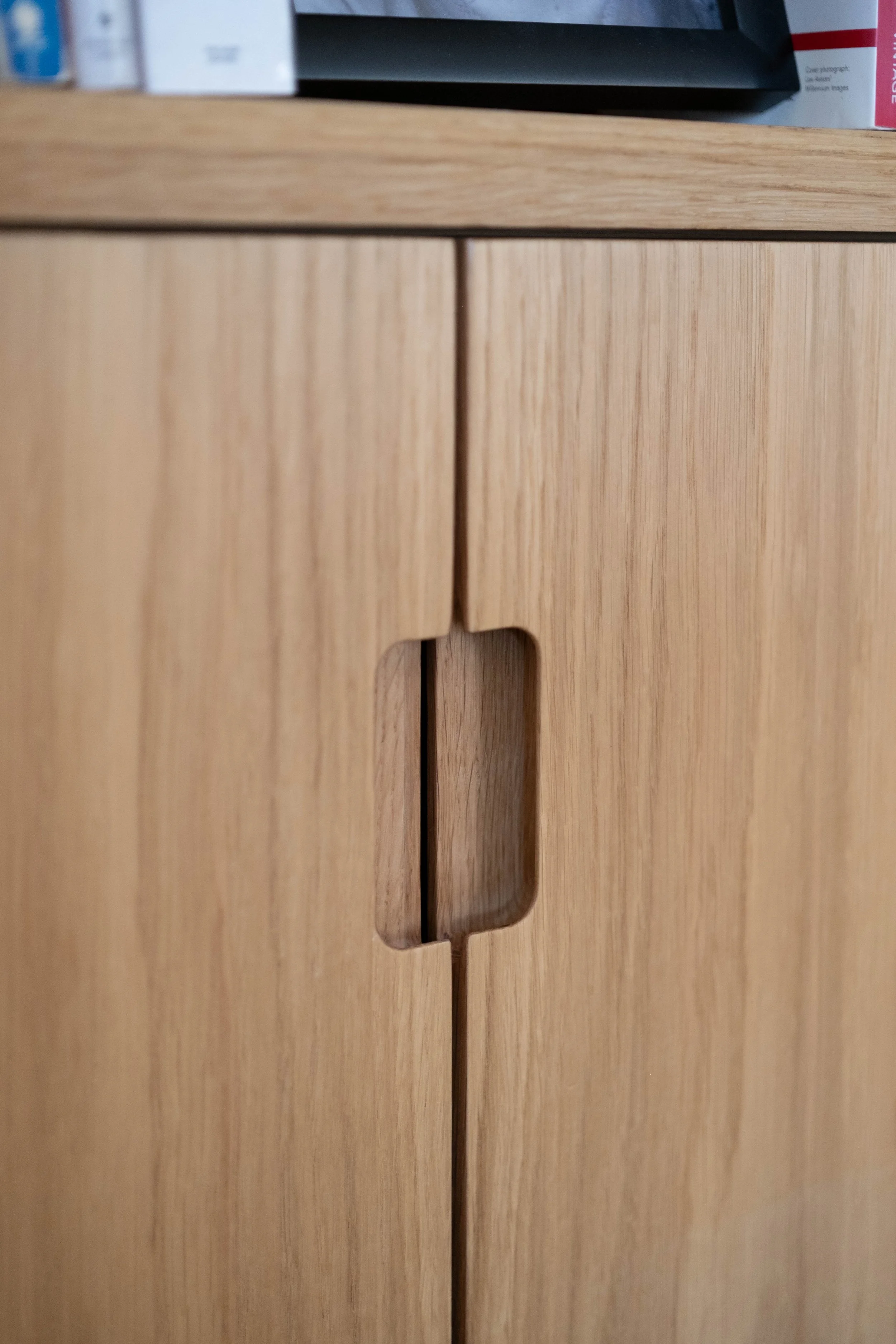 Close-up of wooden cabinet or drawer with a rectangular cutout handle.