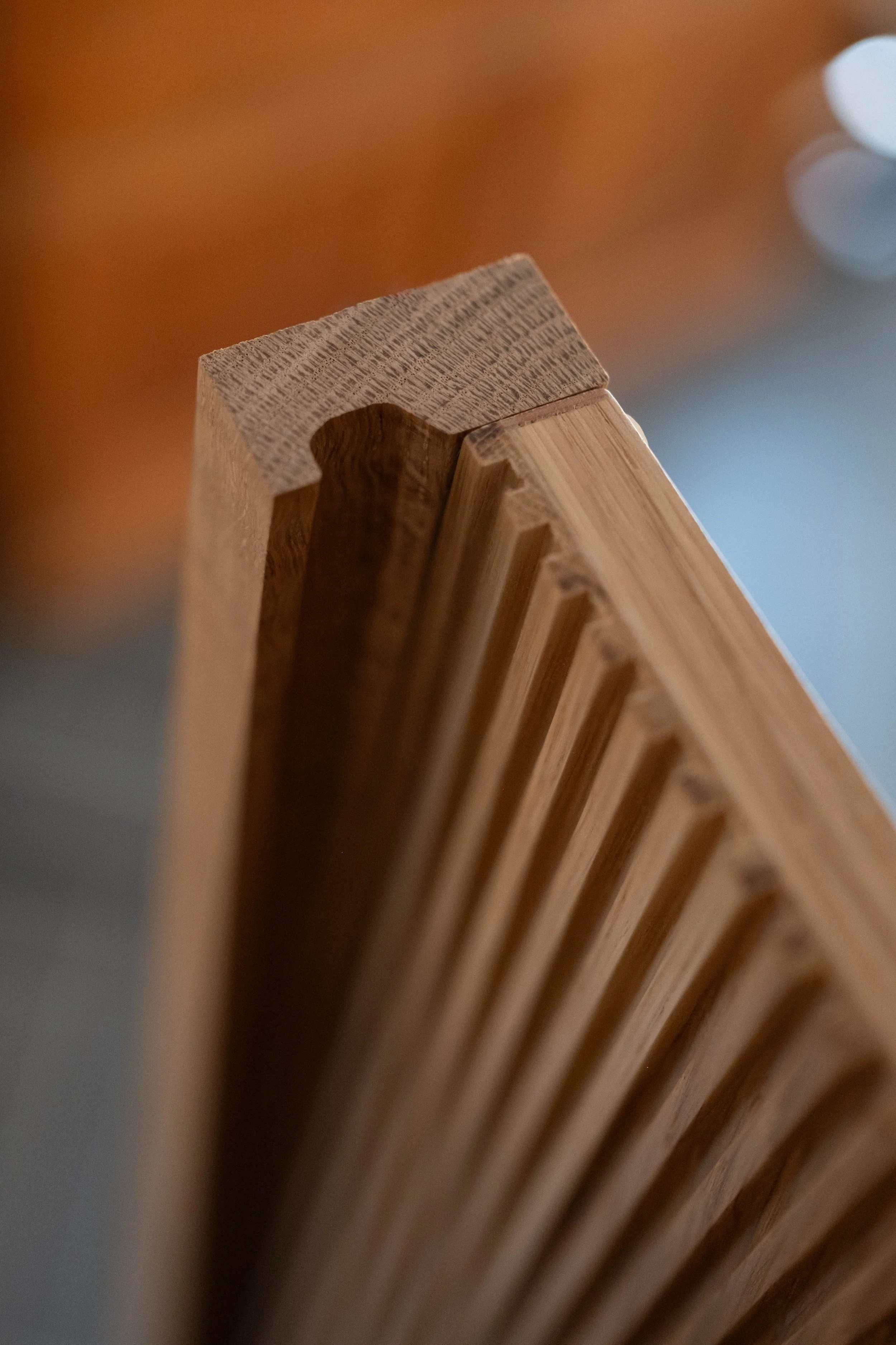 Close-up photo of the corner of a wooden object with multiple evenly spaced slats, showing detailed wood grain and texture.
