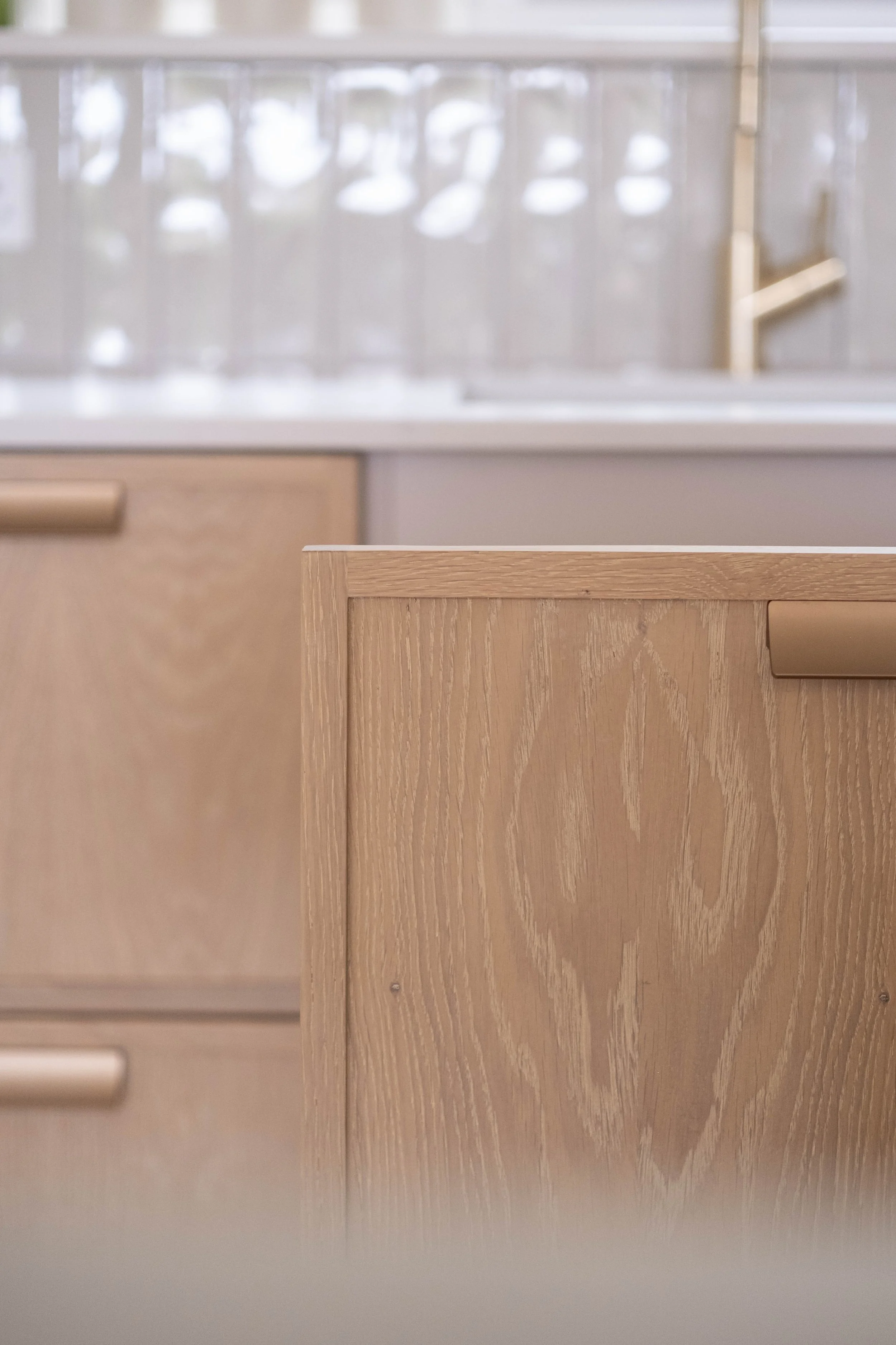Close-up of a light wooden cabinet door with a horizontal handle.