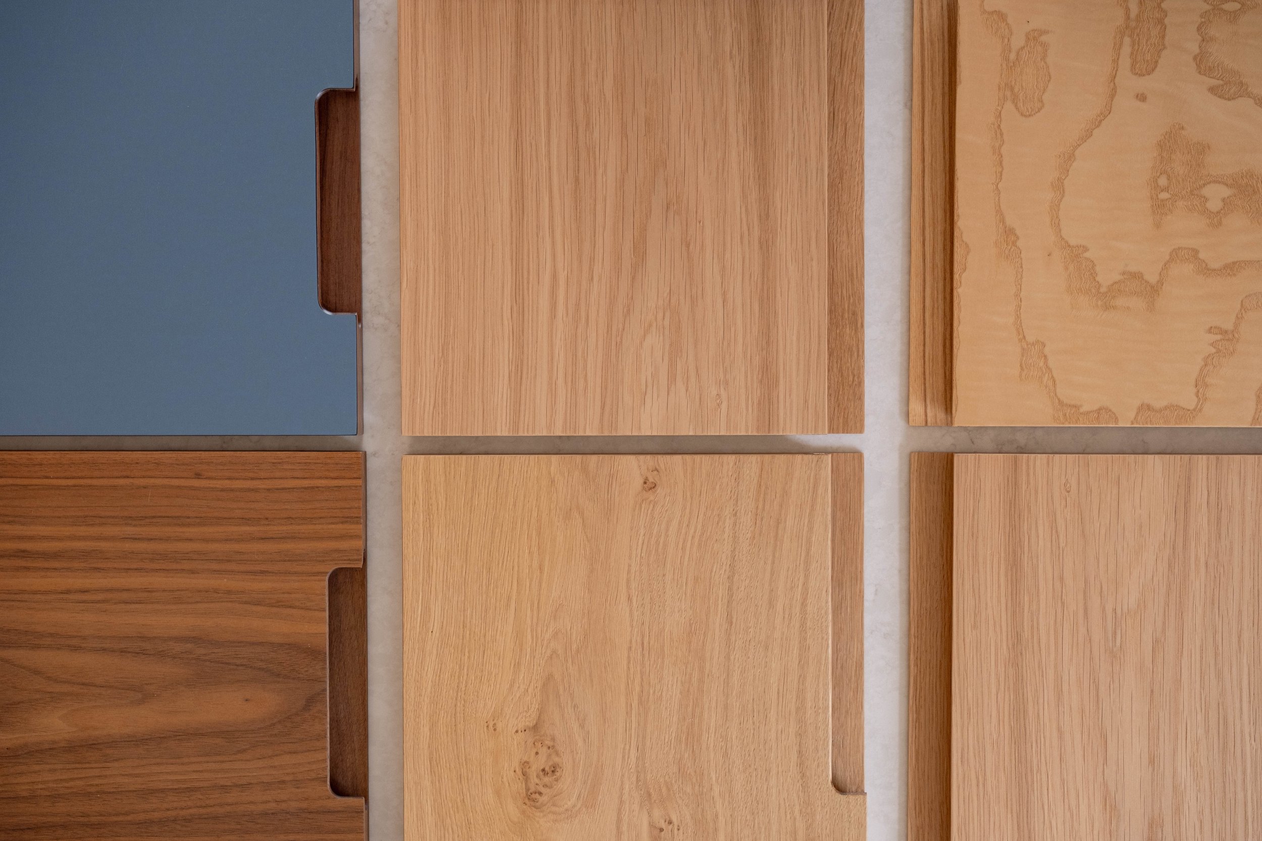 A top-down view of various wood veneer swatches showcasing different wood grains and colors, arranged in a rectangular pattern.