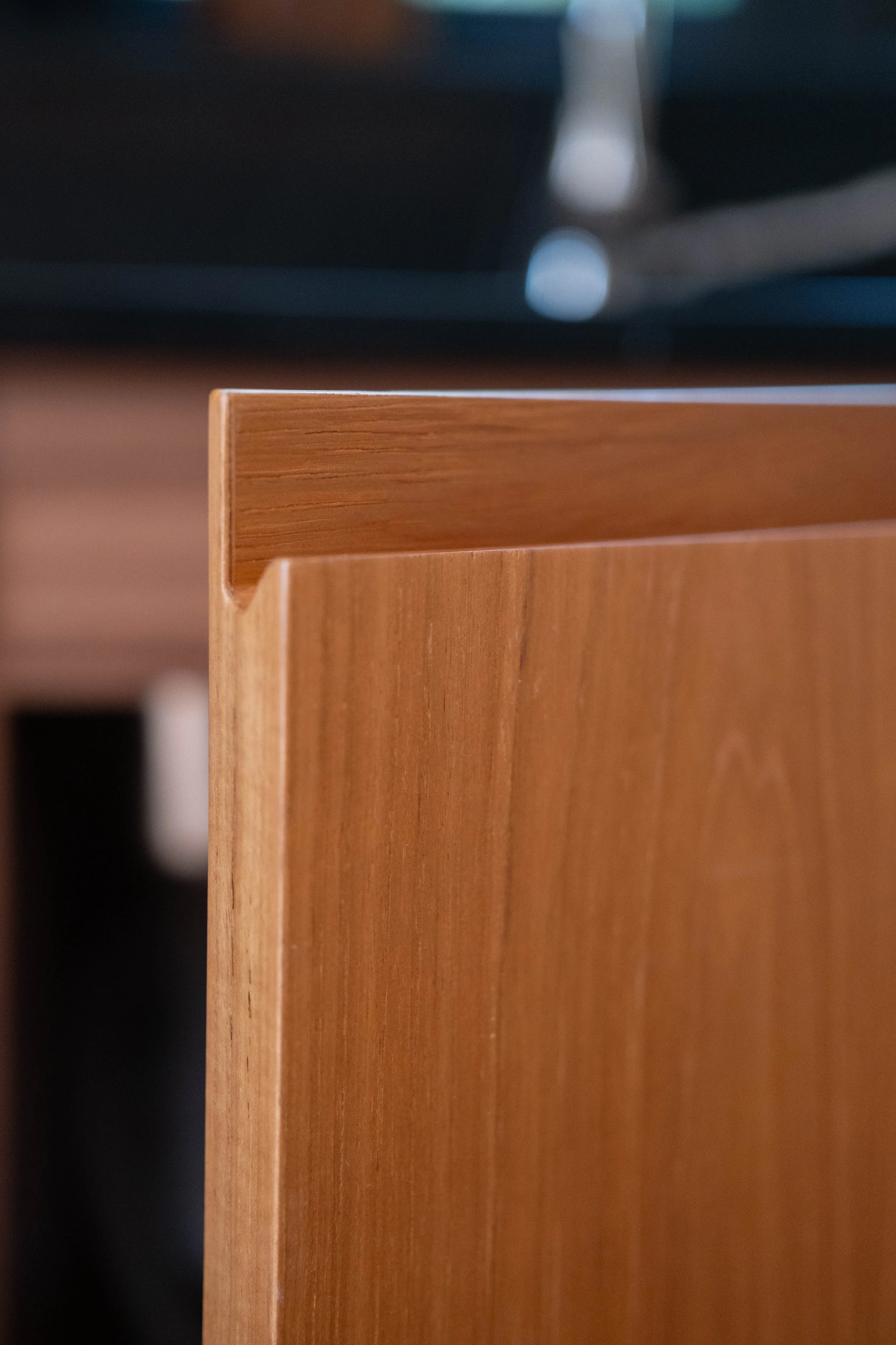 Close-up of a wooden table edge with a blurred background.