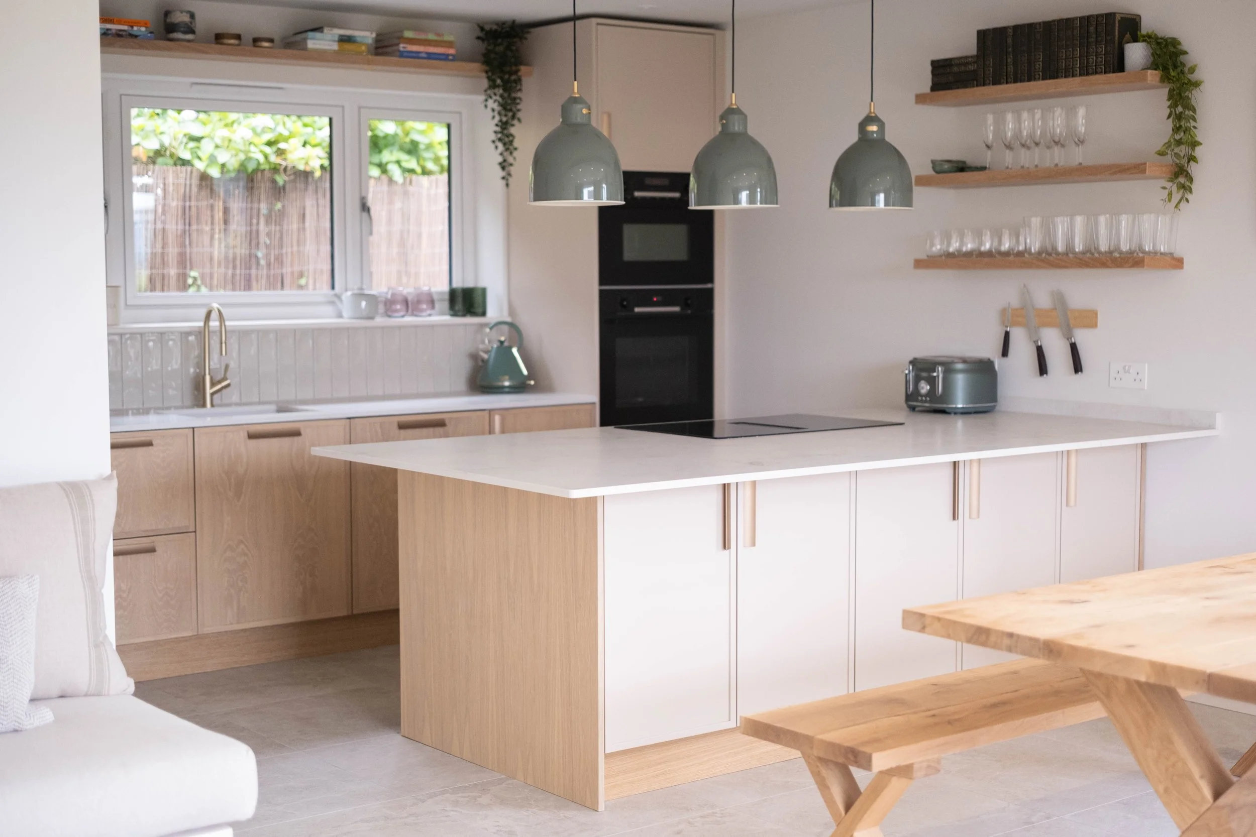 Modern kitchen with open shelves, pendant lights, and a large window.