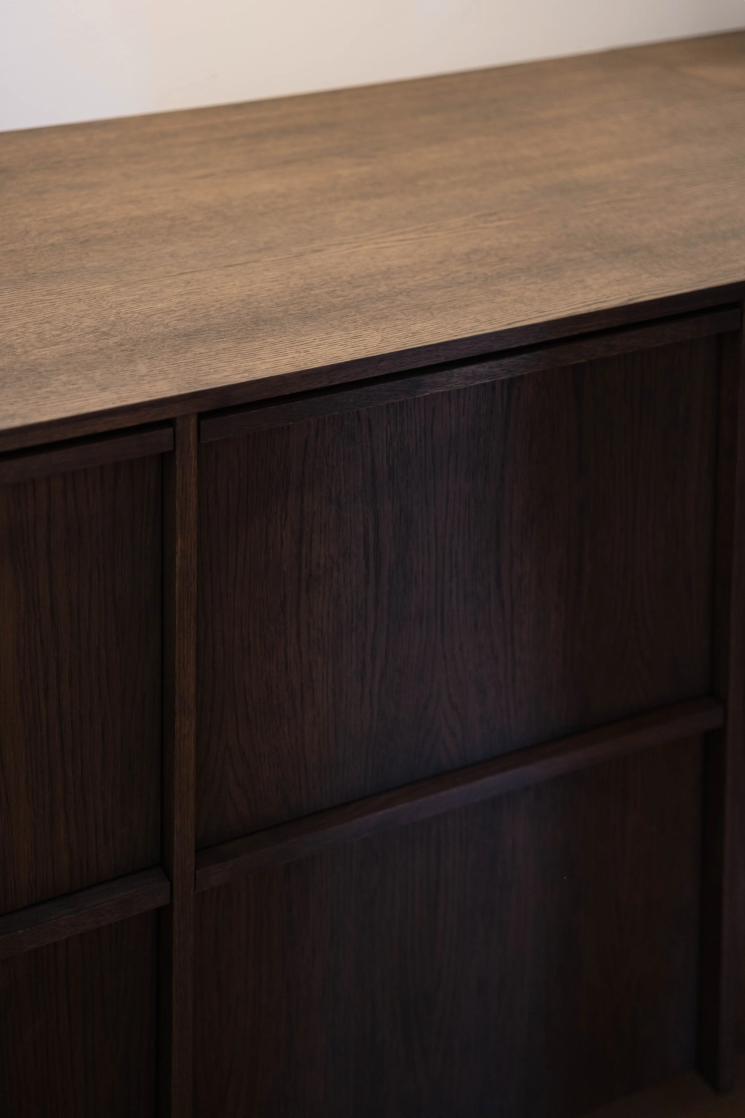 Close-up of a dark wood cabinet with a flat top surface.