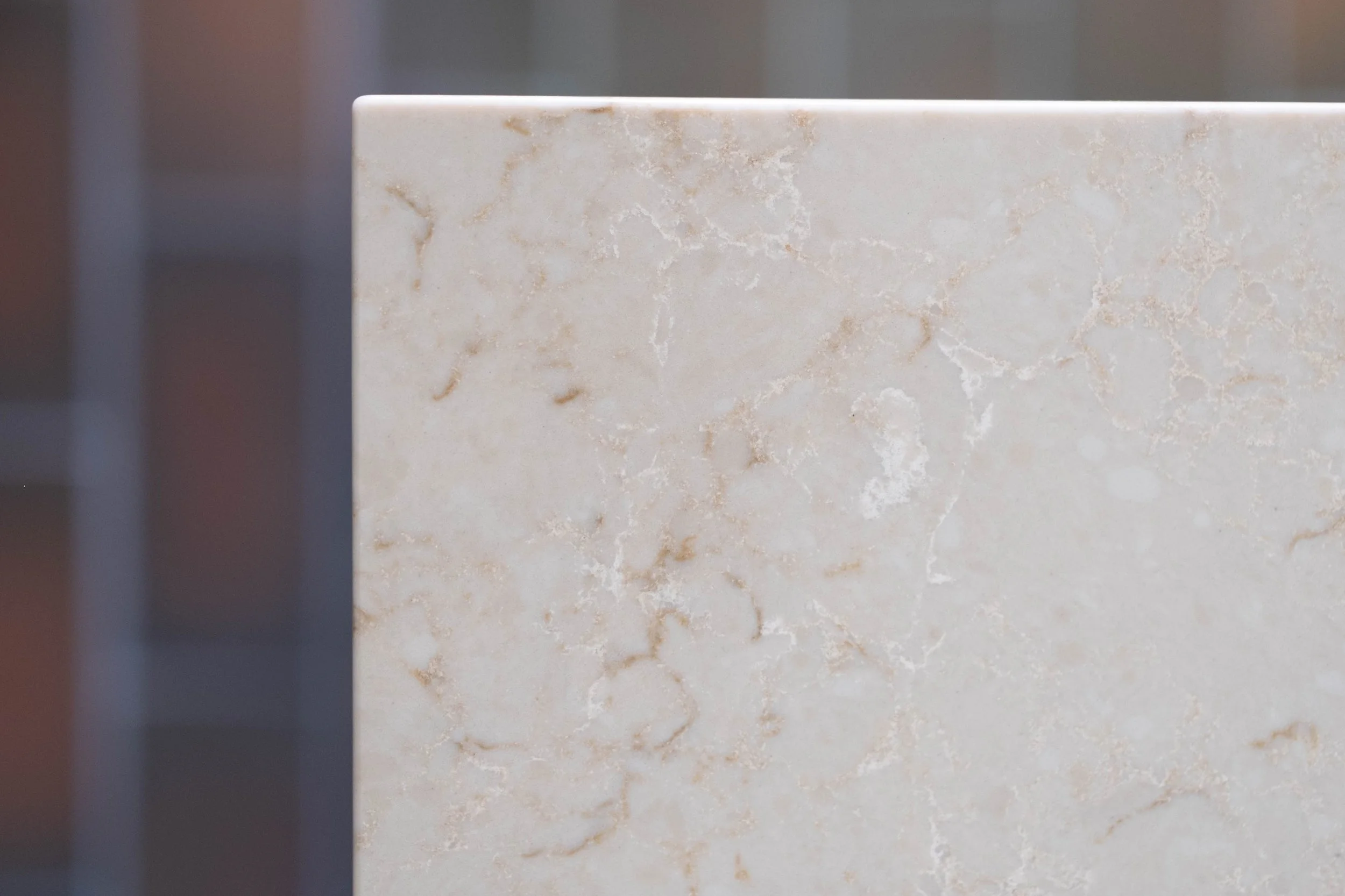 Close-up of a beige marble or stone surface with natural veining and pattern.