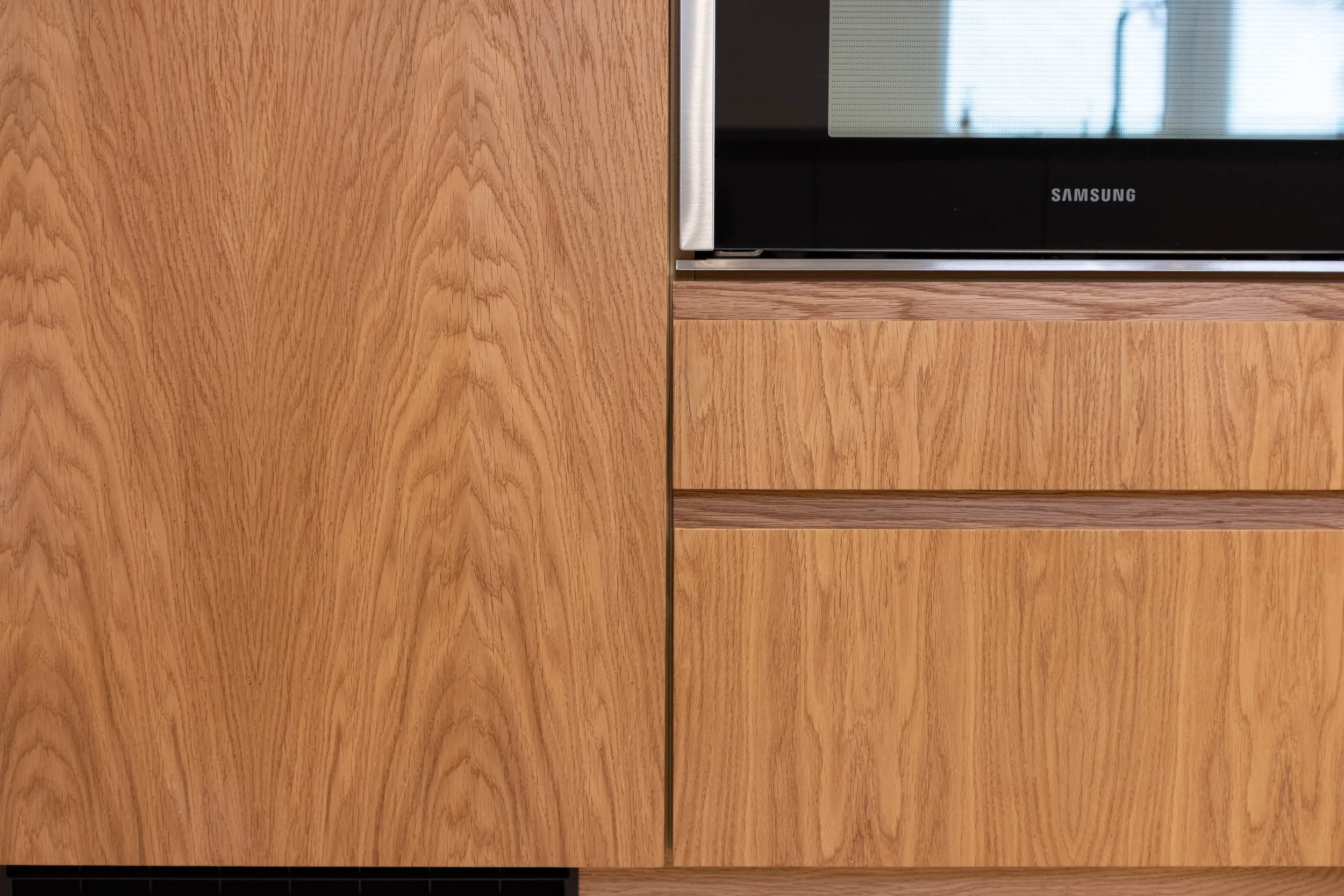 Close-up of a wooden wall with a section of a black Samsung television visible on the right side.