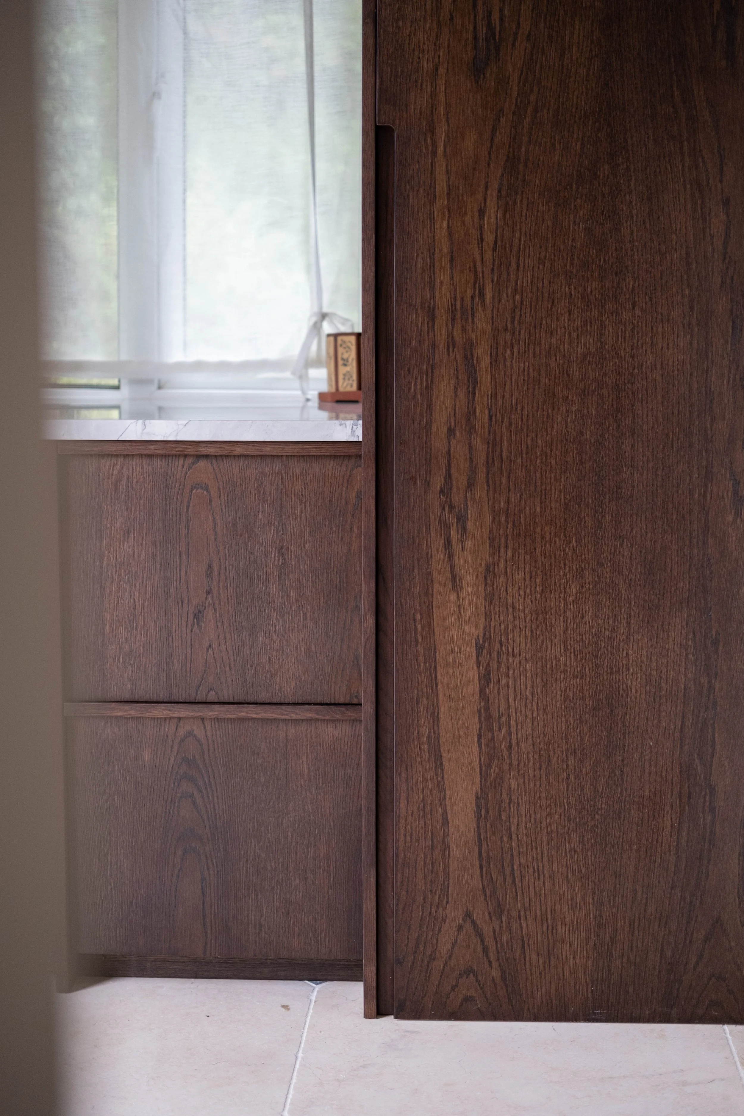 Close-up of wooden cabinet doors with visible wood grain, standing on a tiled floor.