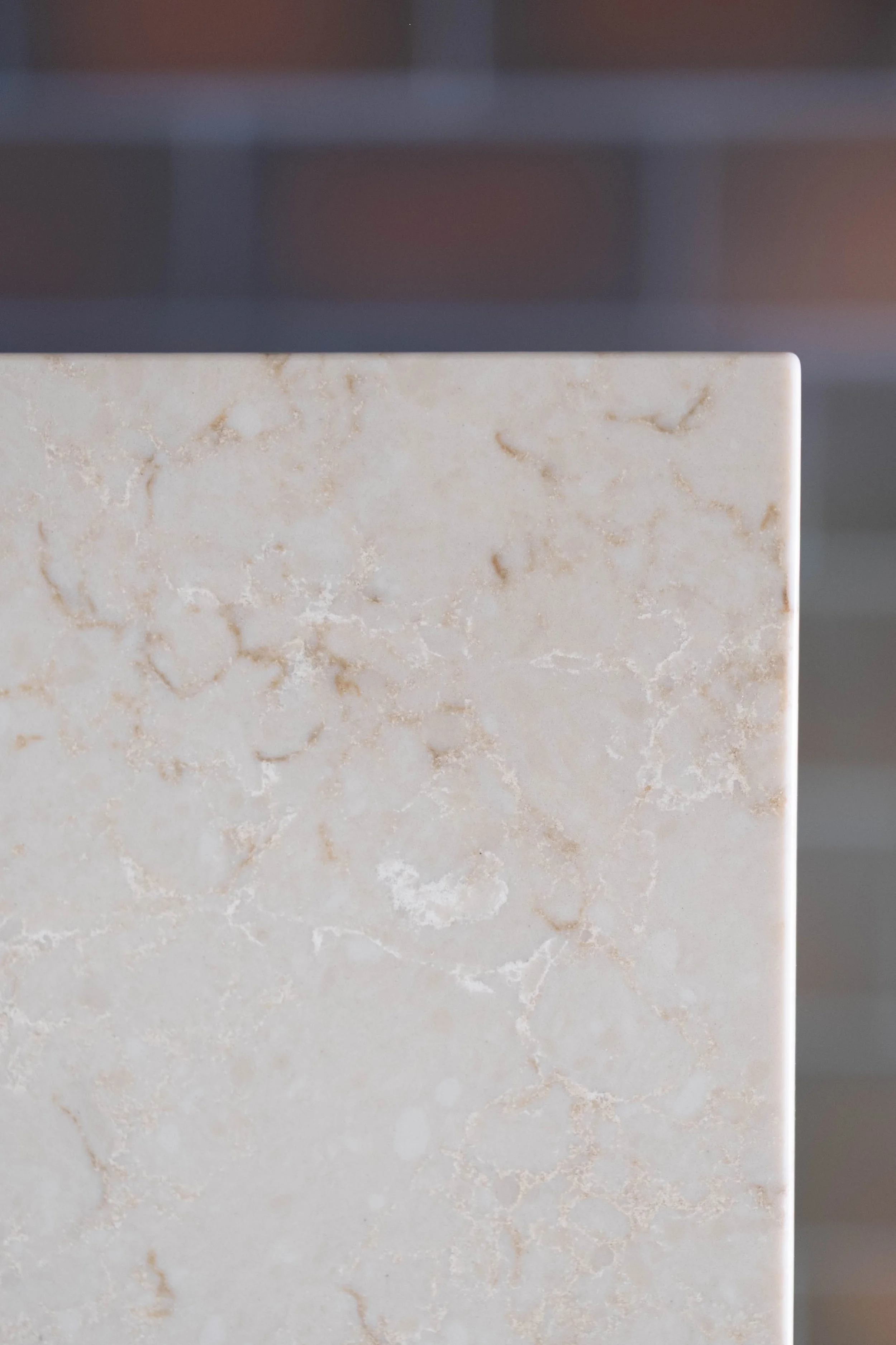 Close-up of a marble surface with beige and cream tones and subtle veining.