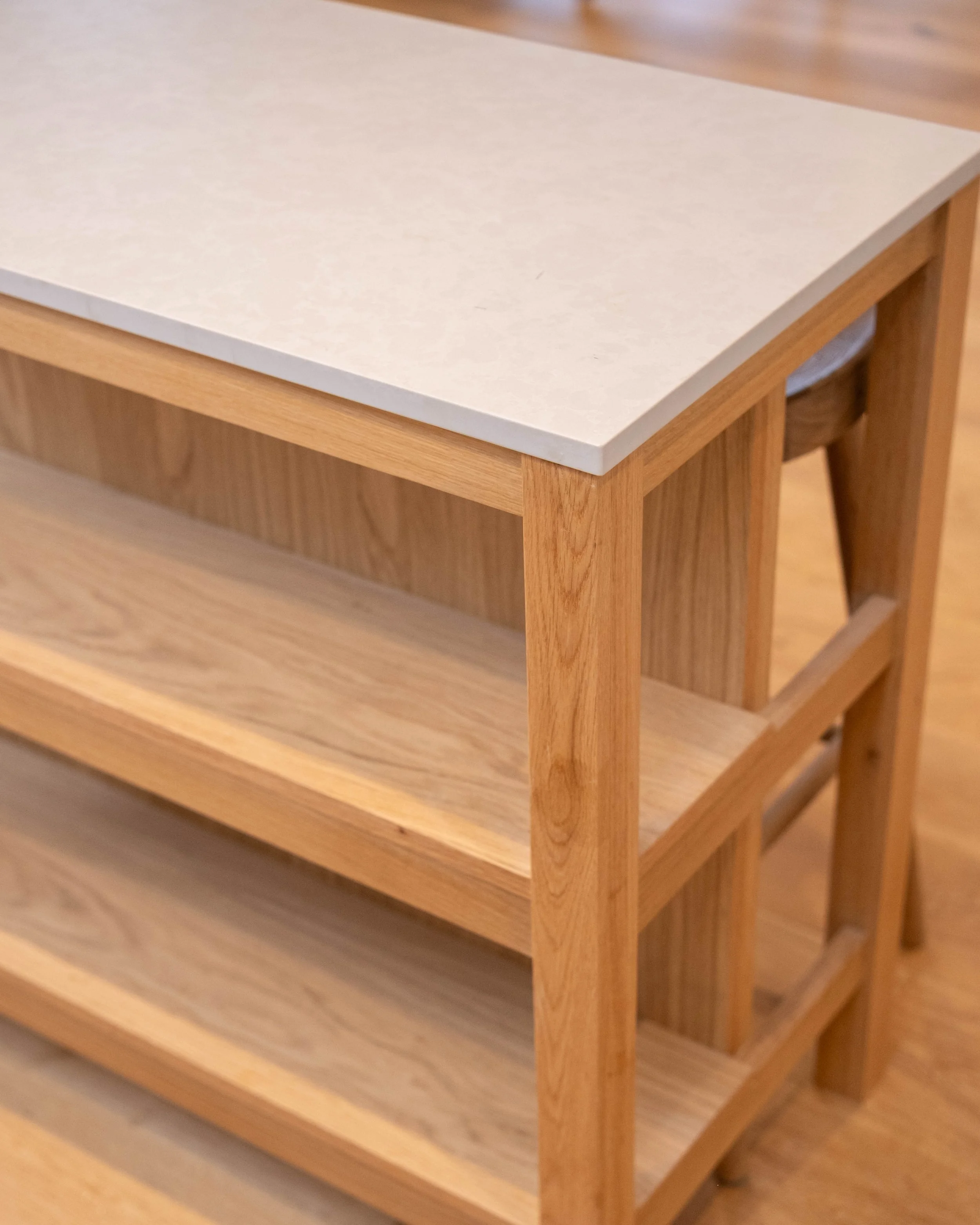 A wooden shelving unit with a light-colored top and darker wooden frame and sides.
