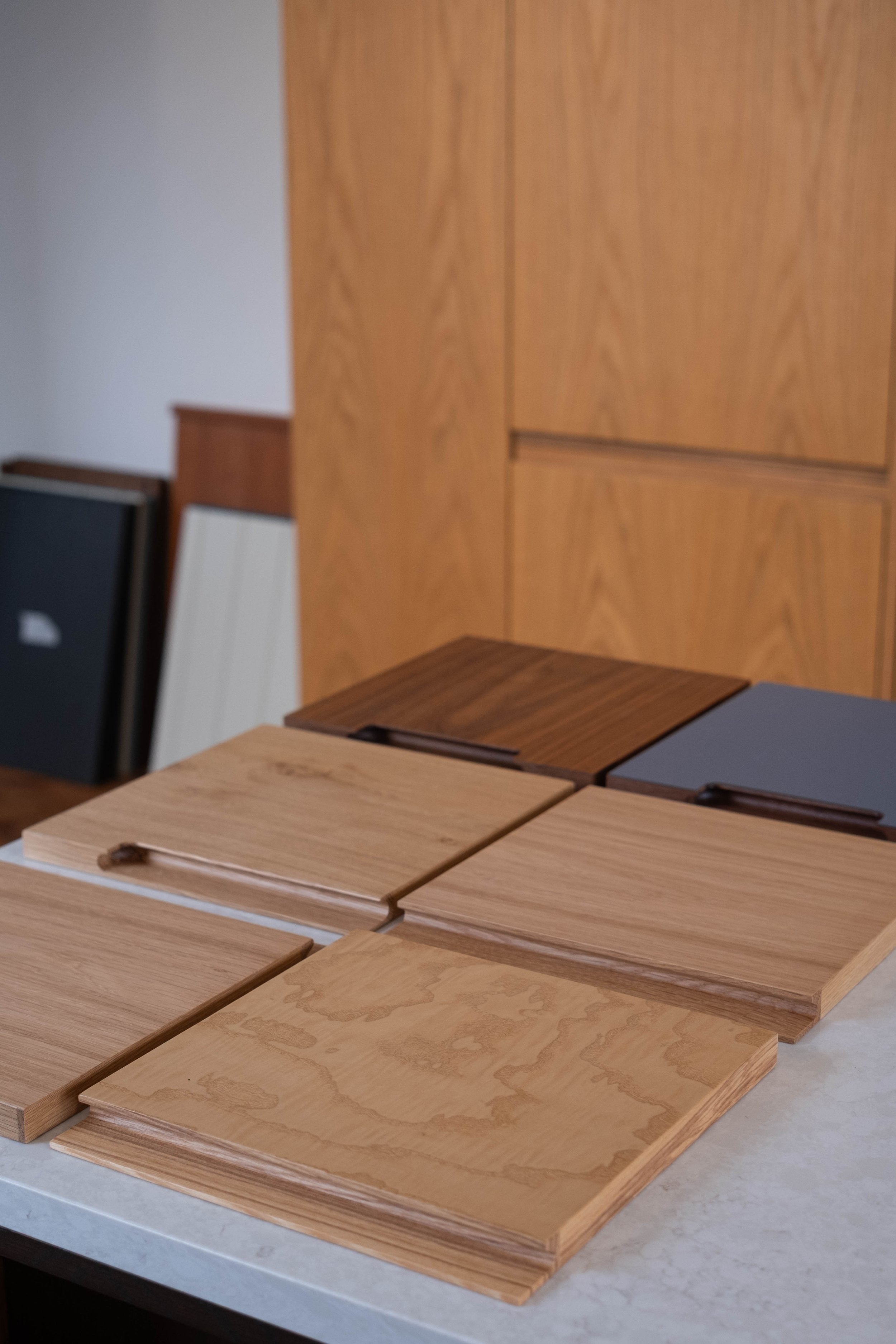 Various wood veneer samples displayed on a white surface, showing different grains and finishes.