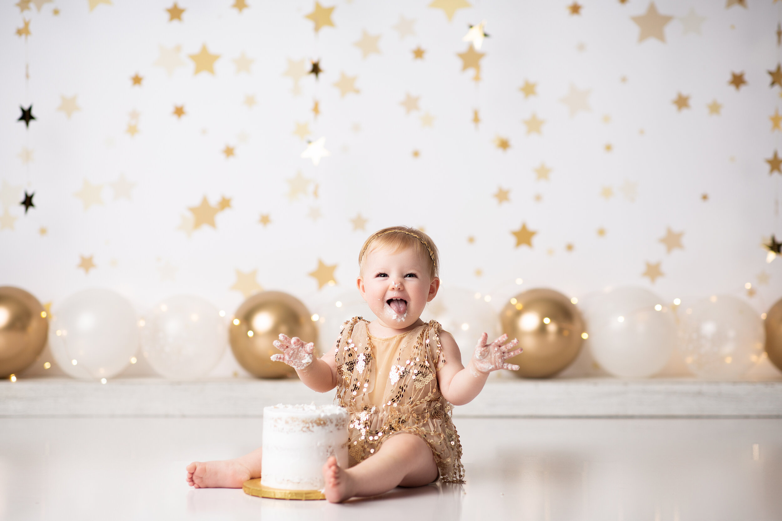  Baby girl laughing excitedly during her custom first birthday smash session 