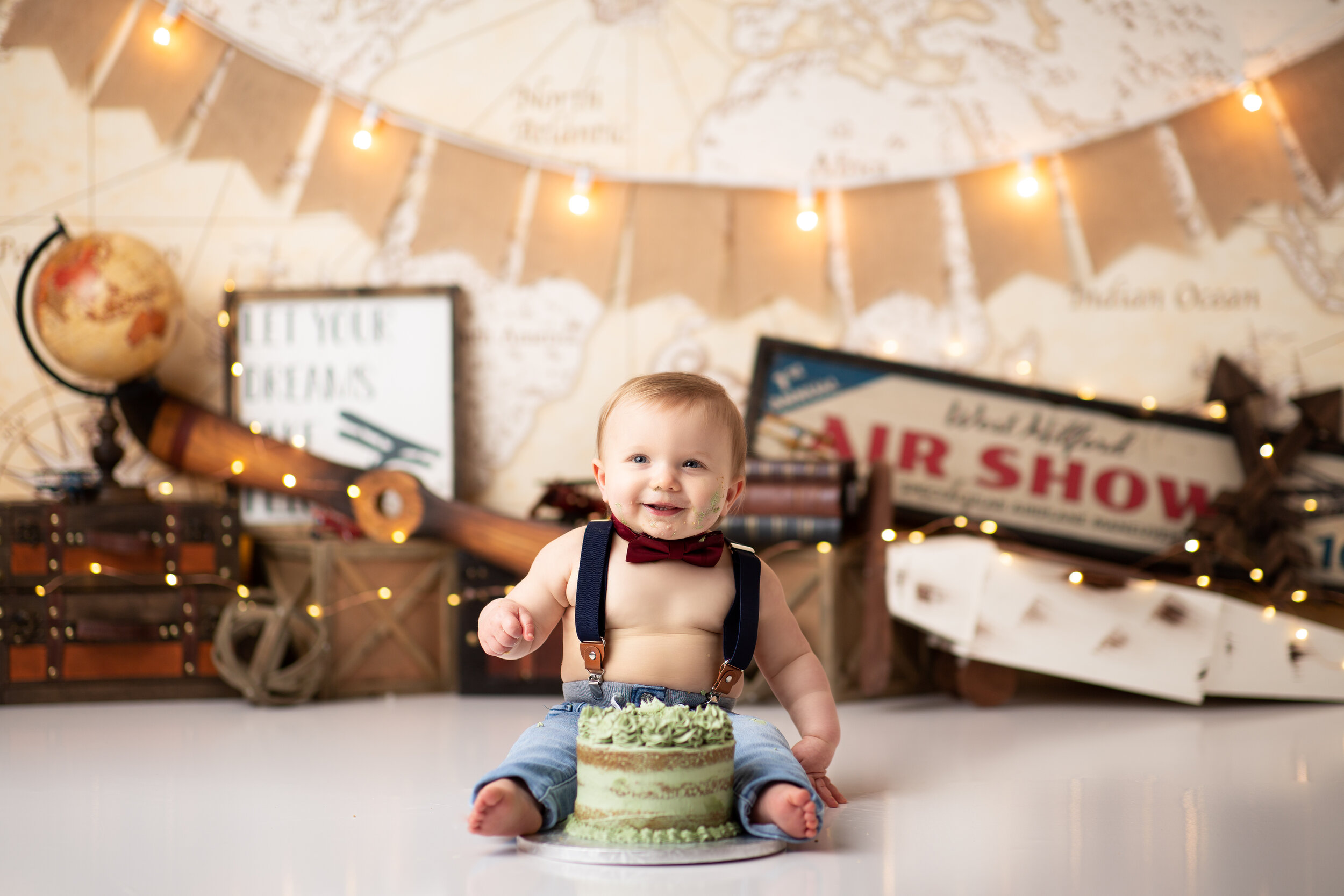  Airplanes, globes, and suitcases create a travel backdrop for little man’s cake smash session 