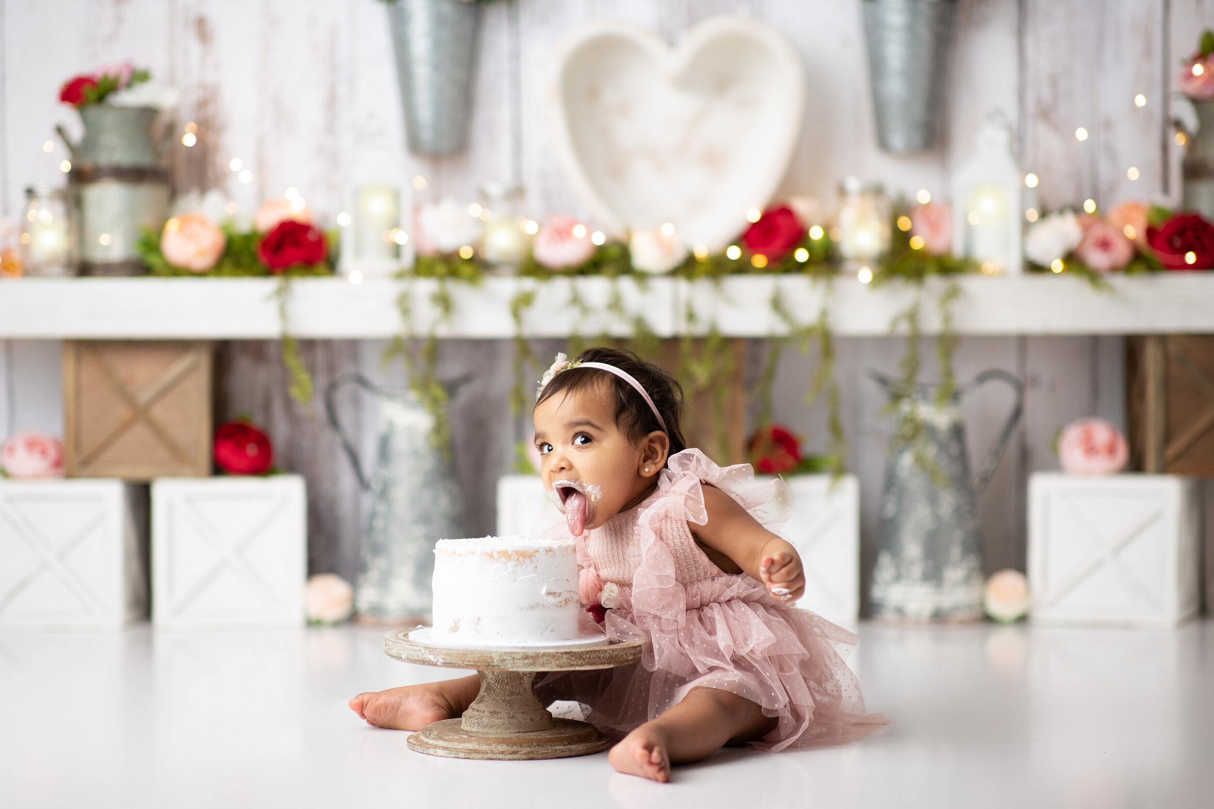  Baby girl leans forward to test her birthday cake face-first  