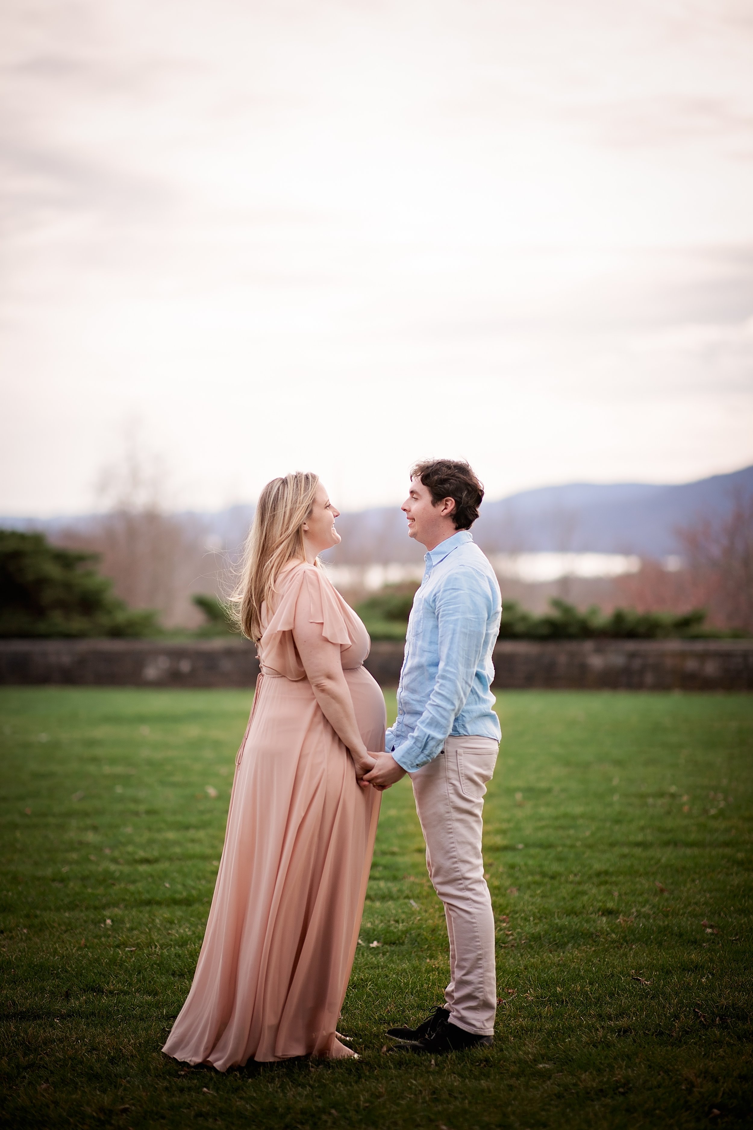  Man and pregnant woman holding hands and gazing into each other’s eyes 