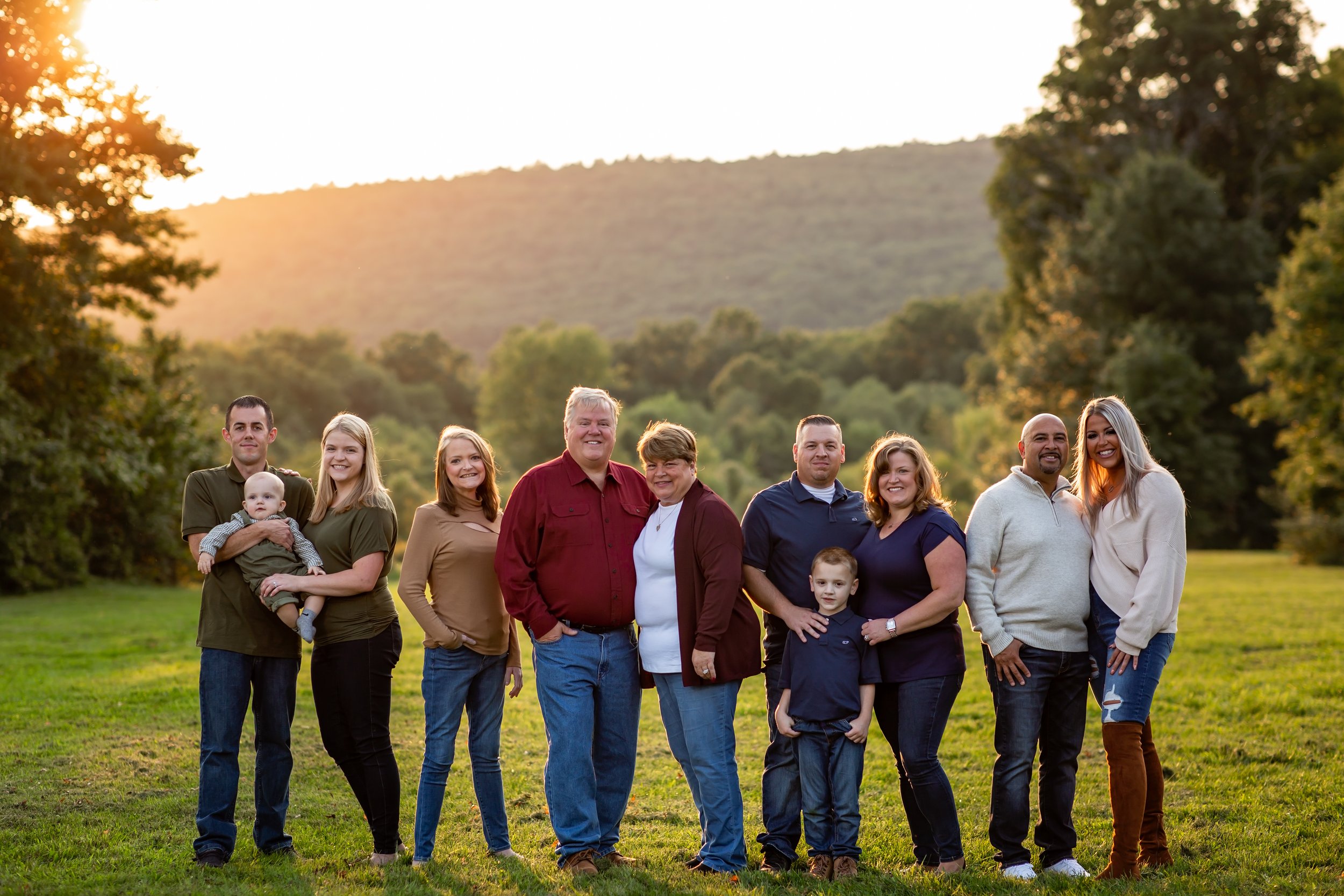  Man and woman surrounded by their children and grandchildren in a sunny New Jersey field 