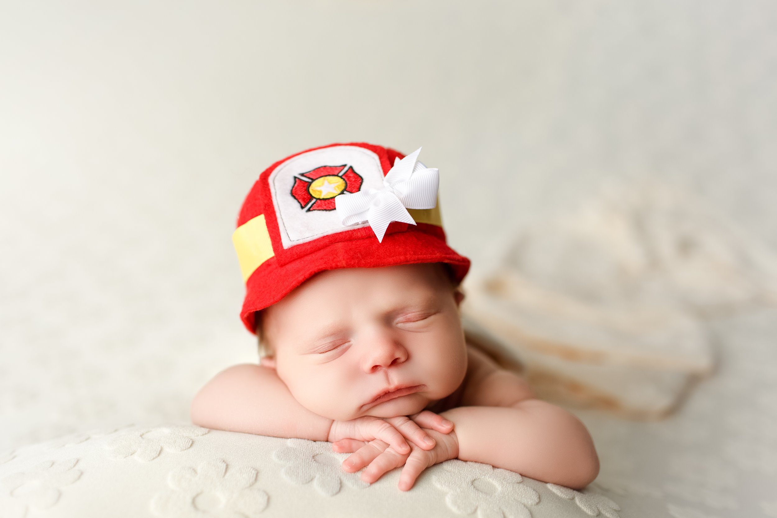  Baby girl in soft felt firefighter’s hat with a bow 