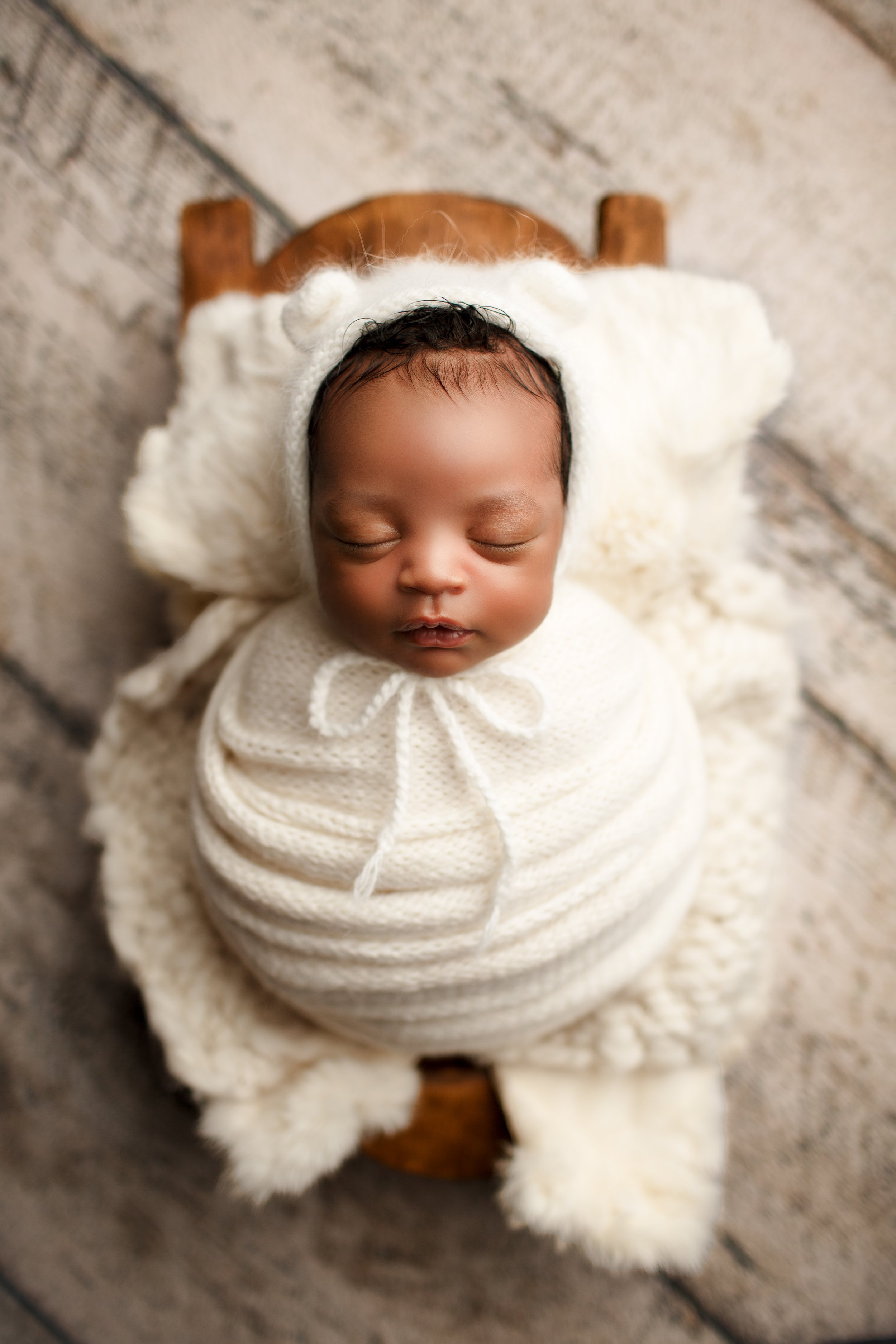  African American baby in white swaddle asleep in New Jersey photo studio 