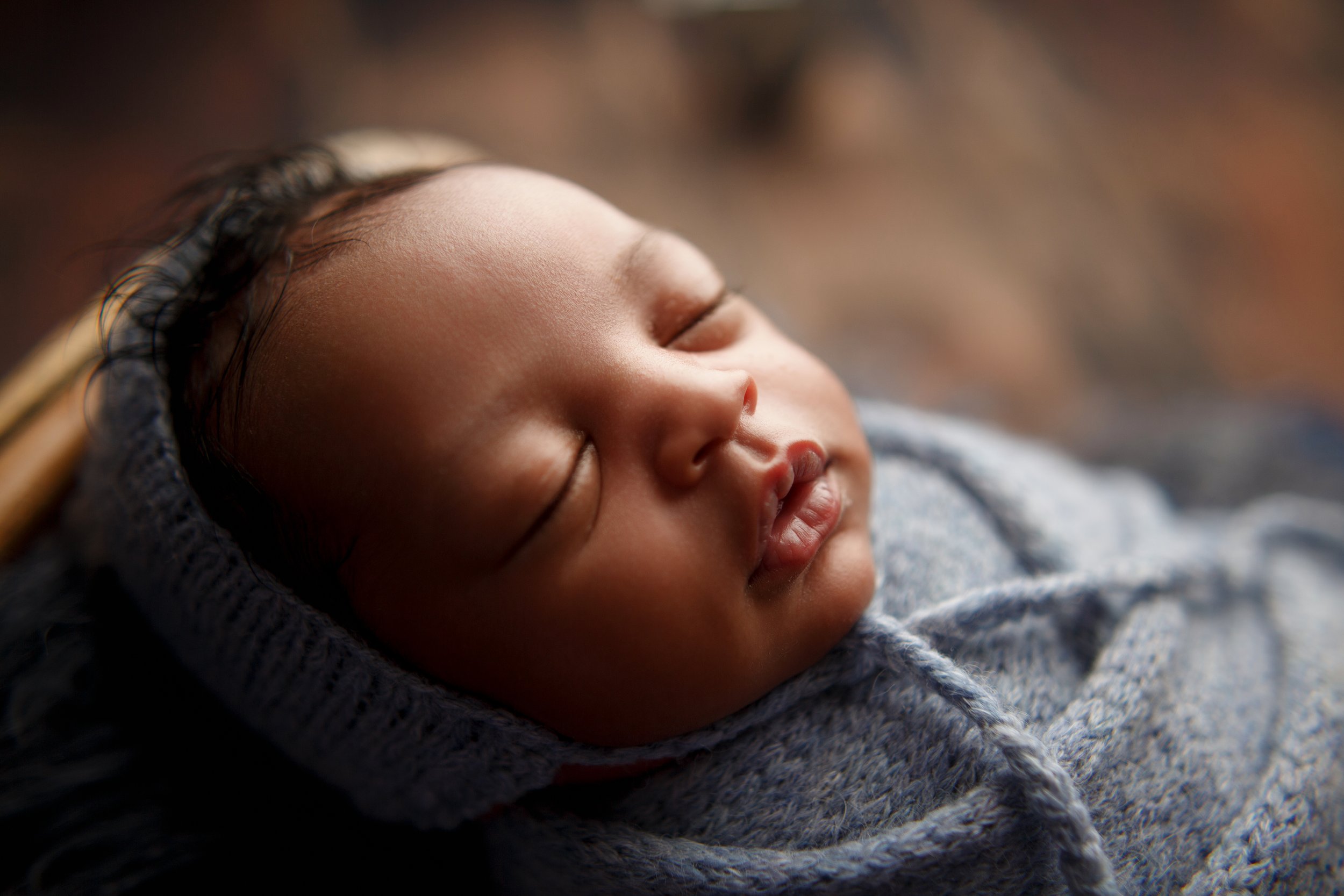  Closeup of baby’s face as he sleeps peacefully through his newborn photoshoot in the Tri-State area 