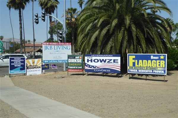 Francois used this caption for his photograph of a fence covered with campaign signs: des élections locales auront lieu le 5 juin en Californie . In English, this reads: local elections will be held June 5 in California.