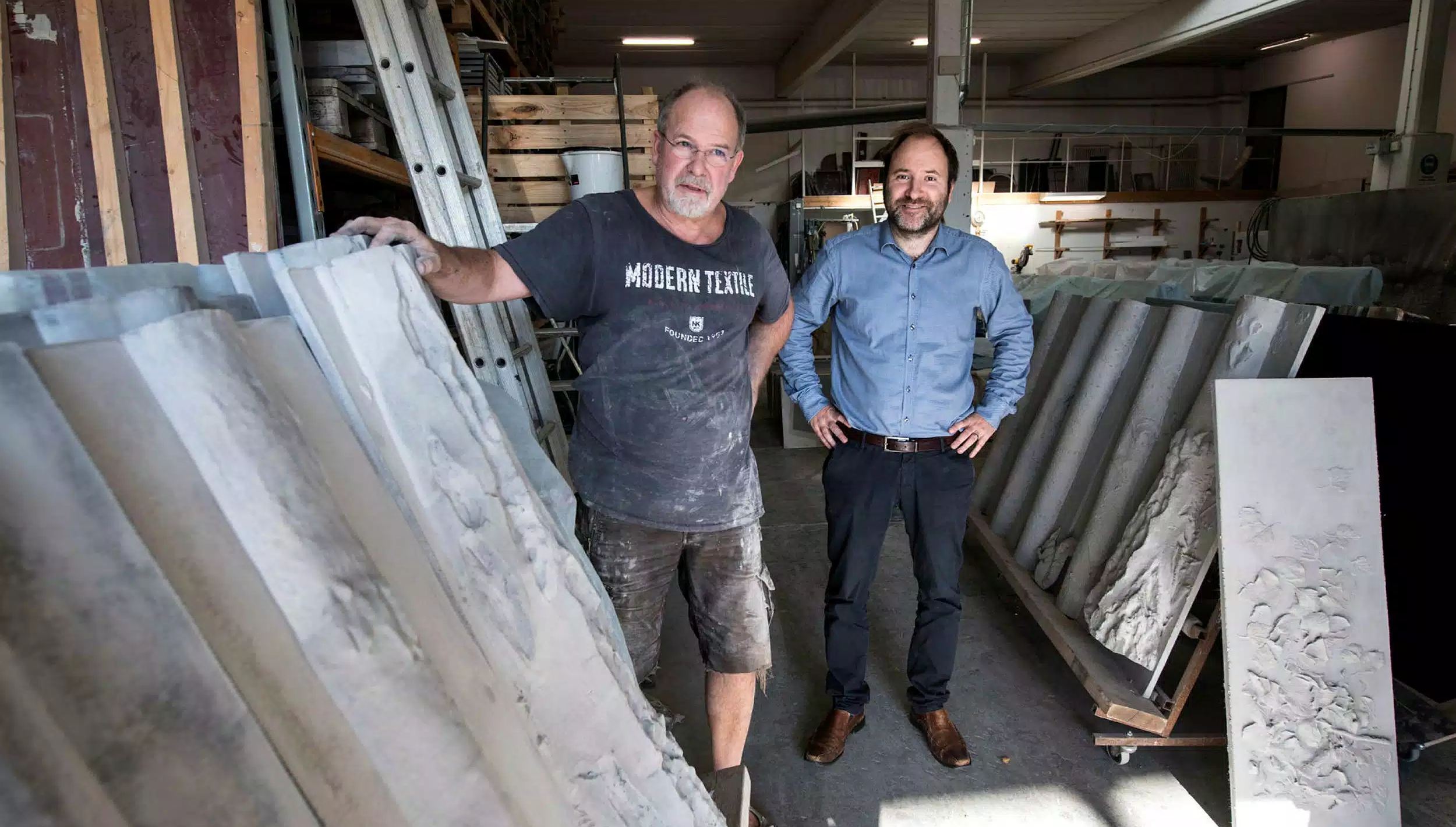 Hans Ekbladh och Daniel Monsén med betongpanelerna som gjutits i Ängelholm. "Det är kul att få lägga pengar på konst när man bygger ett hus", säger Daniel. Bild: Niklas Gustavsson