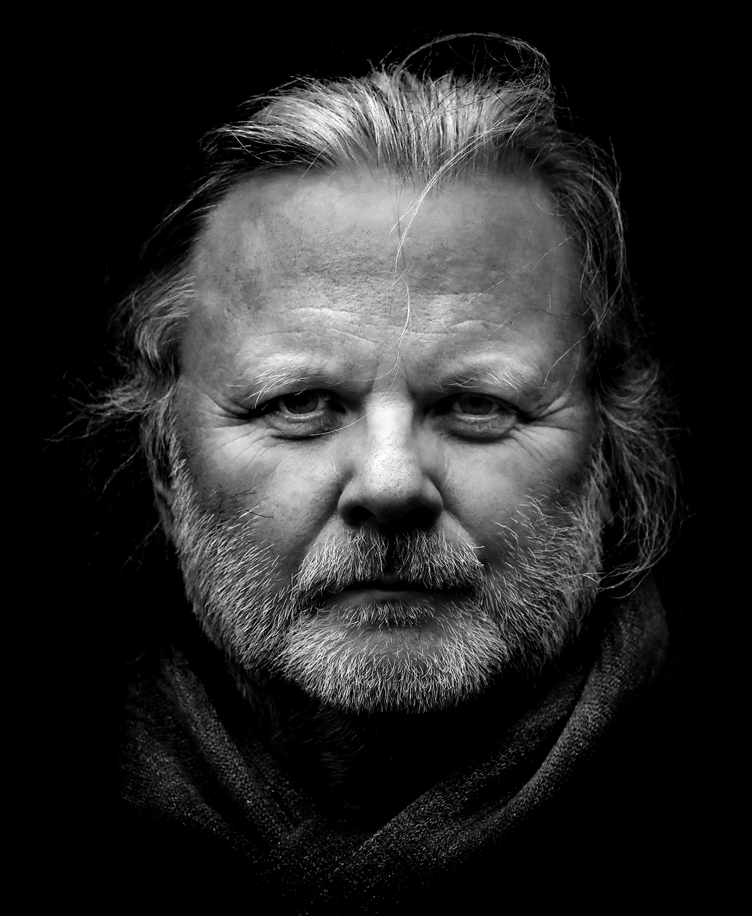 Black and white portrait of Nobel laureate Jon Fosse wearing a black coat and scarf