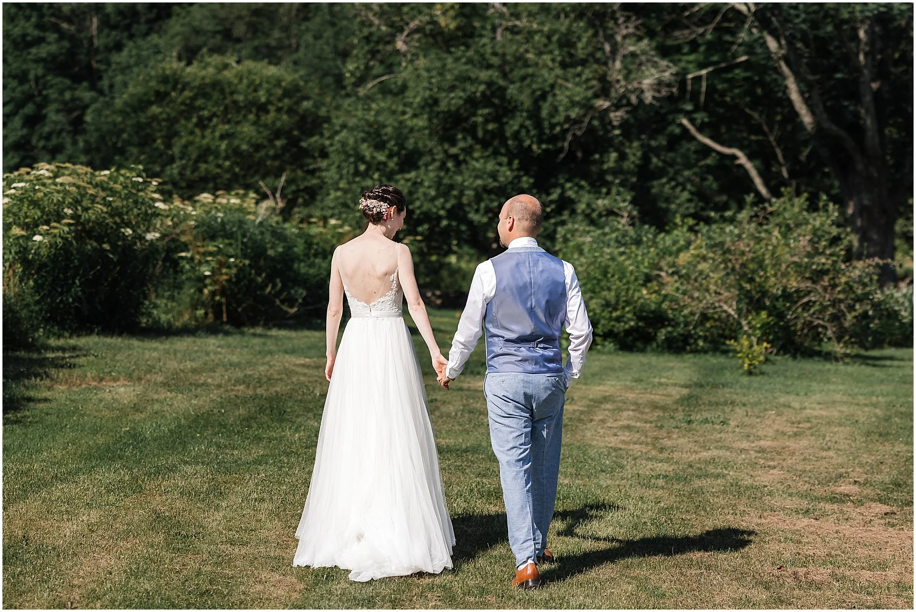 Newlyweds walking the property at their wedding venue in Upstate New York, The Inn at West Settlement