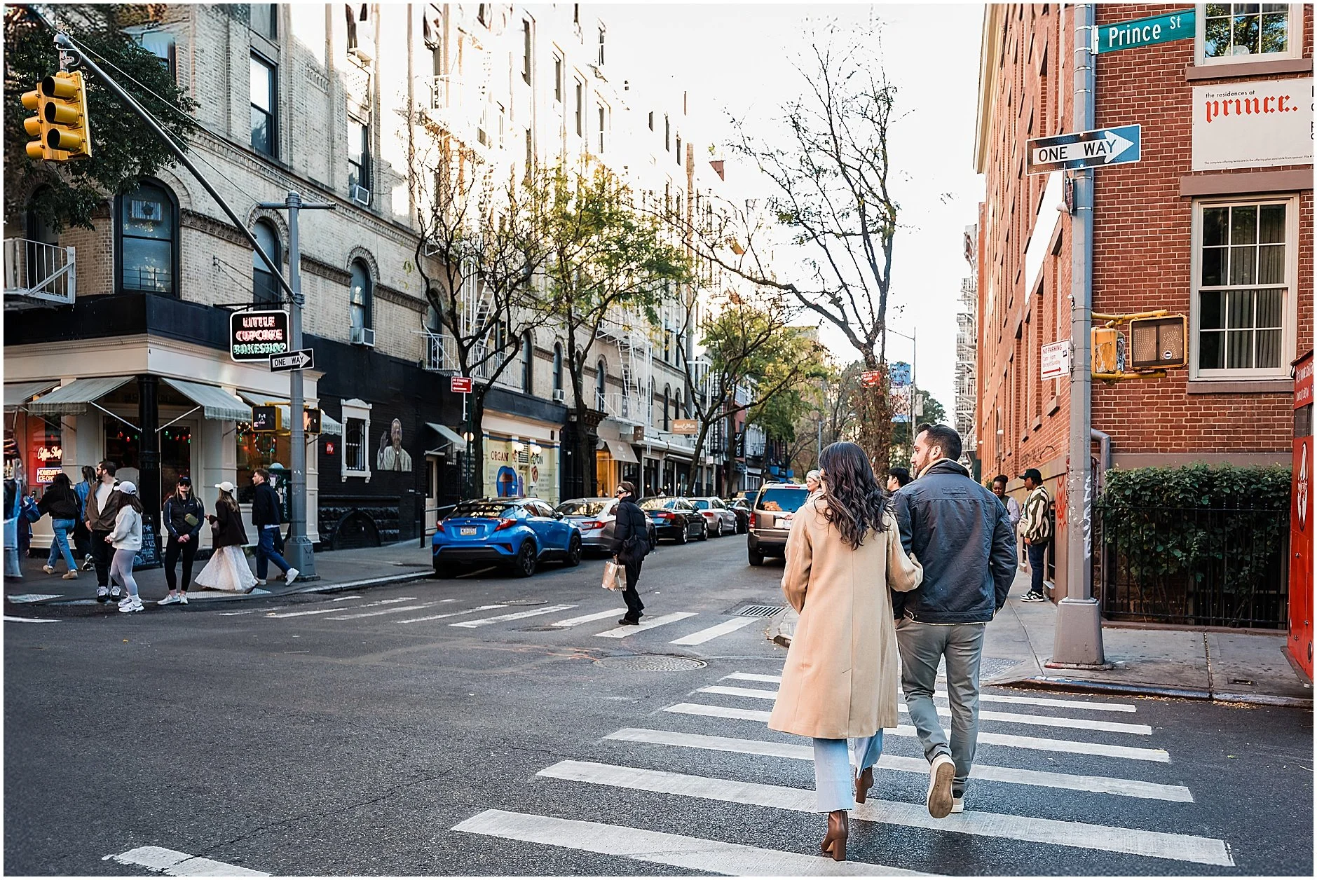 Engaged couple walking across the street in Soho Manhattan during their engagement photos