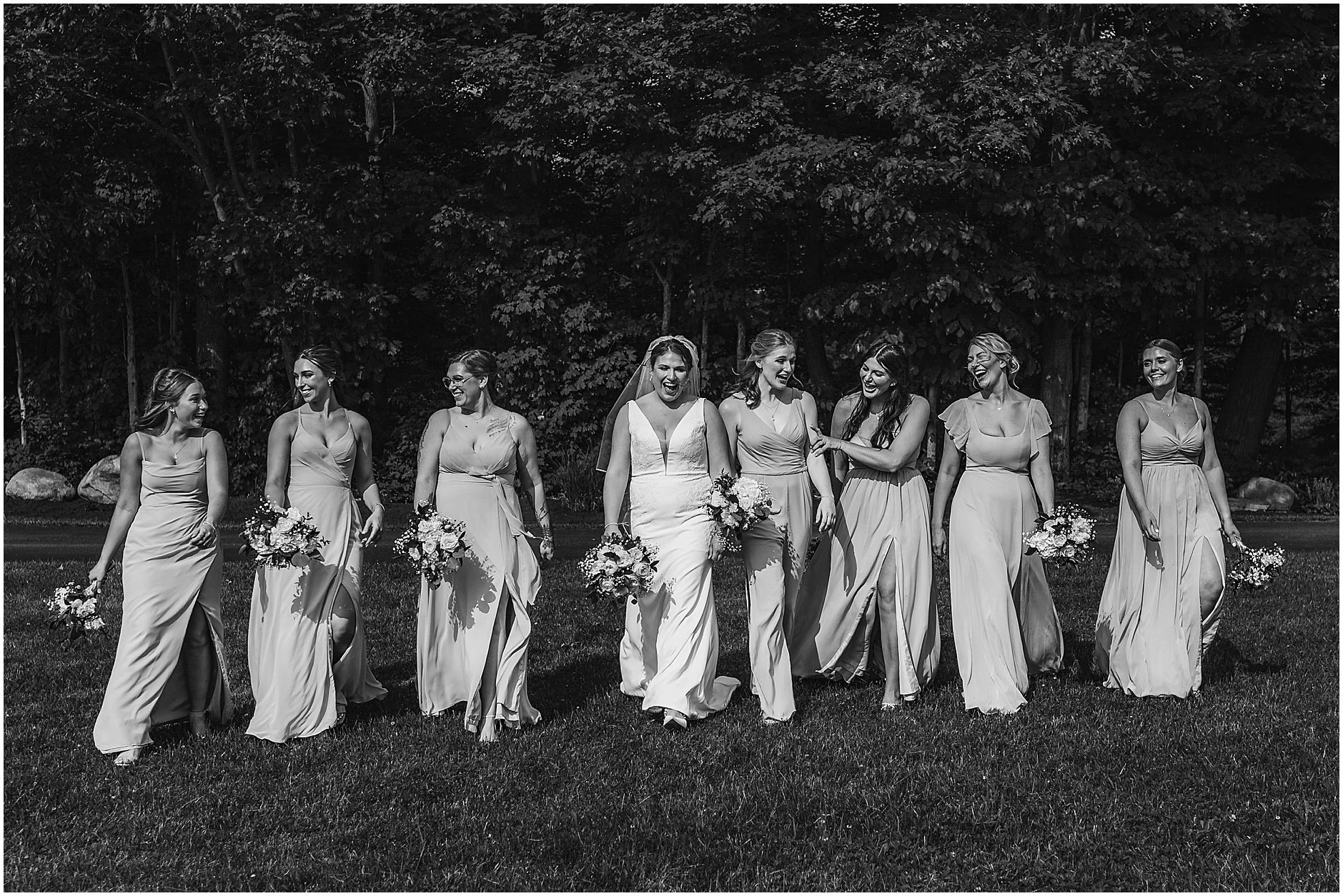 Black and white image of an Upstate New York bride with her bridesmaids walking together before the ceremony.