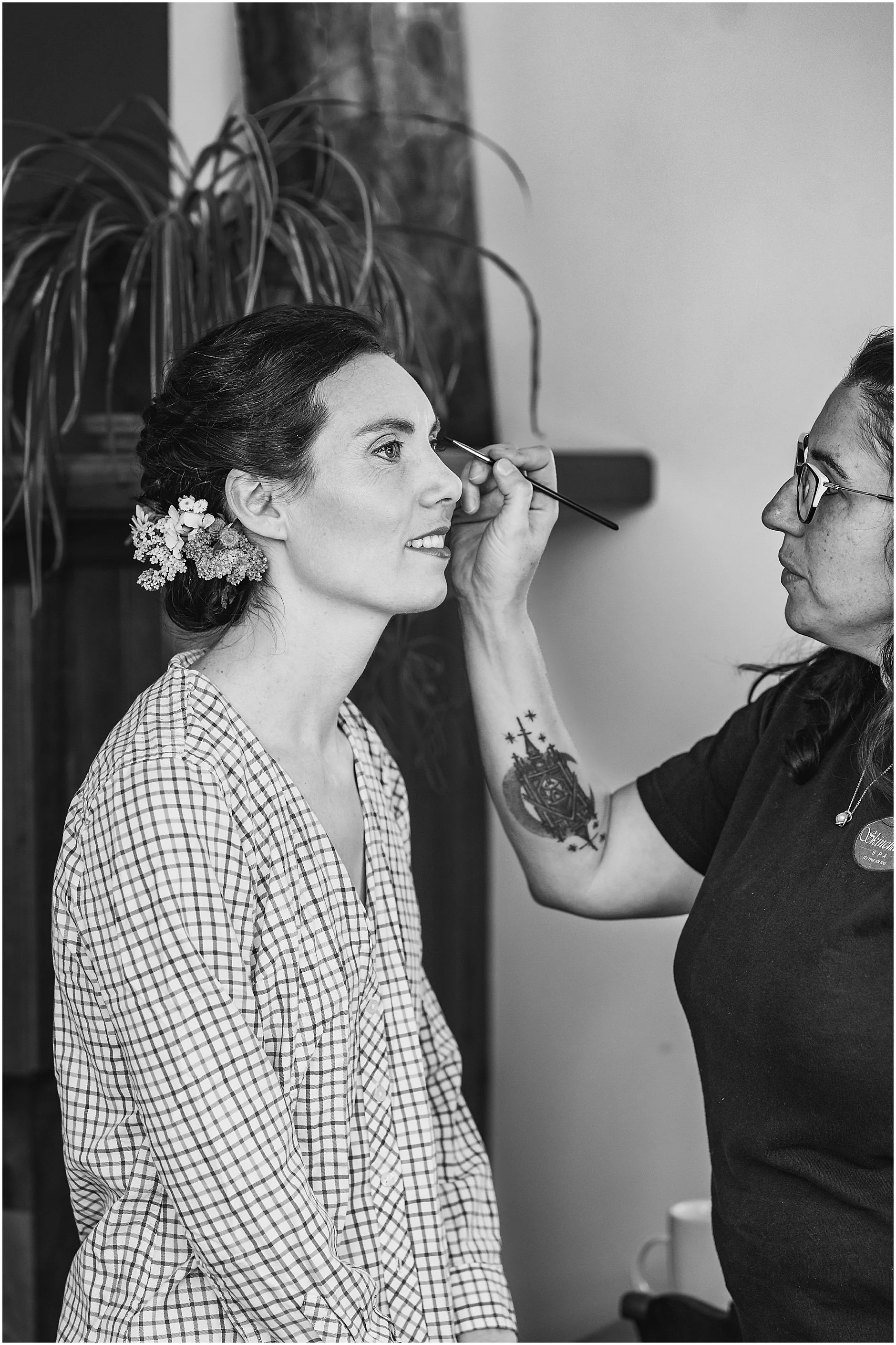 Black and white image of the bride getting her makeup done before her wedding at a venue in the Catskills, NY, The Inn at West Settlement